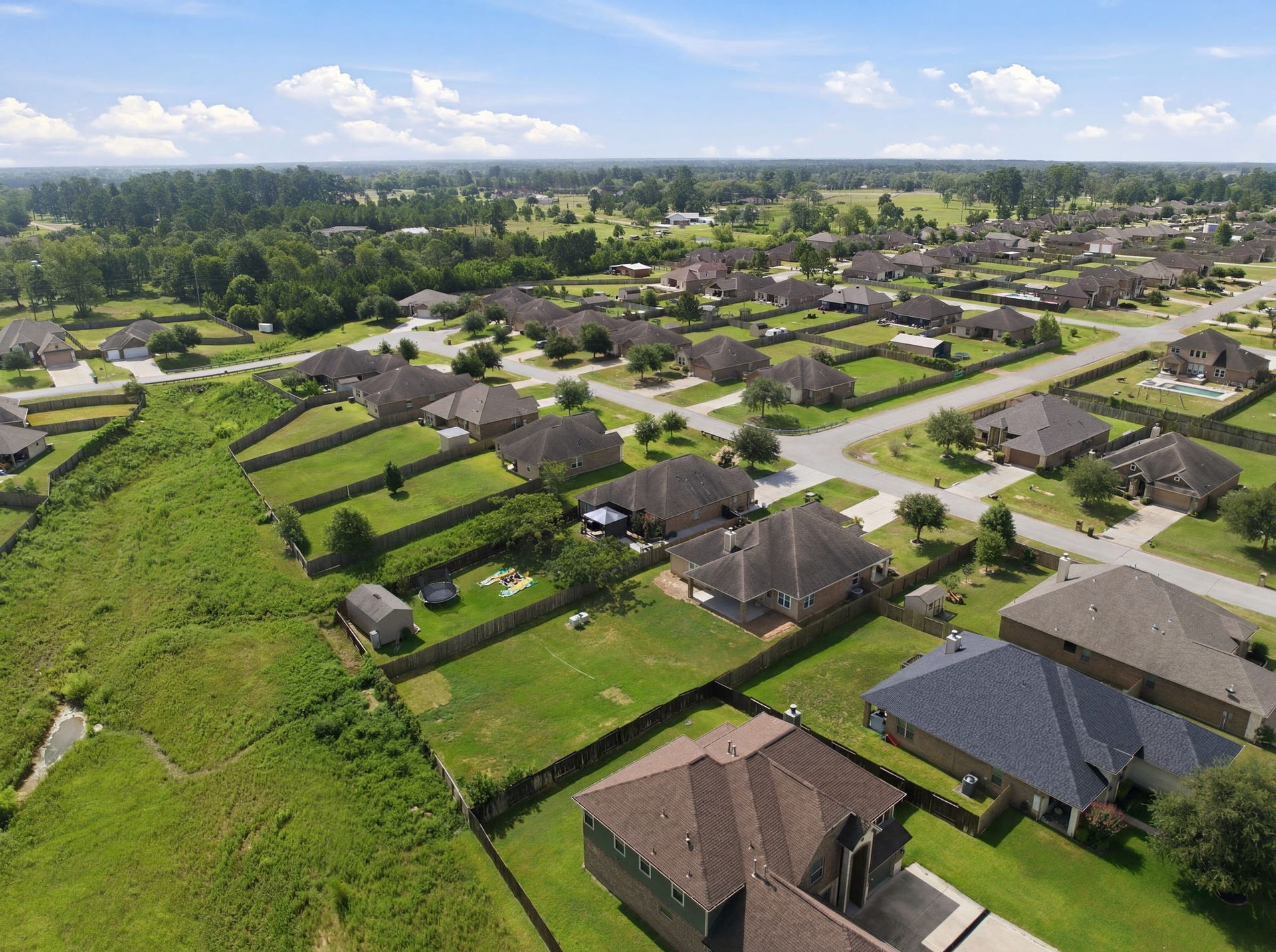 18818 Wichita Trail, Magnolia, TX 77355 Aerial overview of the neighborhood highlights the private lot with no back neighbors, showing the sprawling green space behind the property.