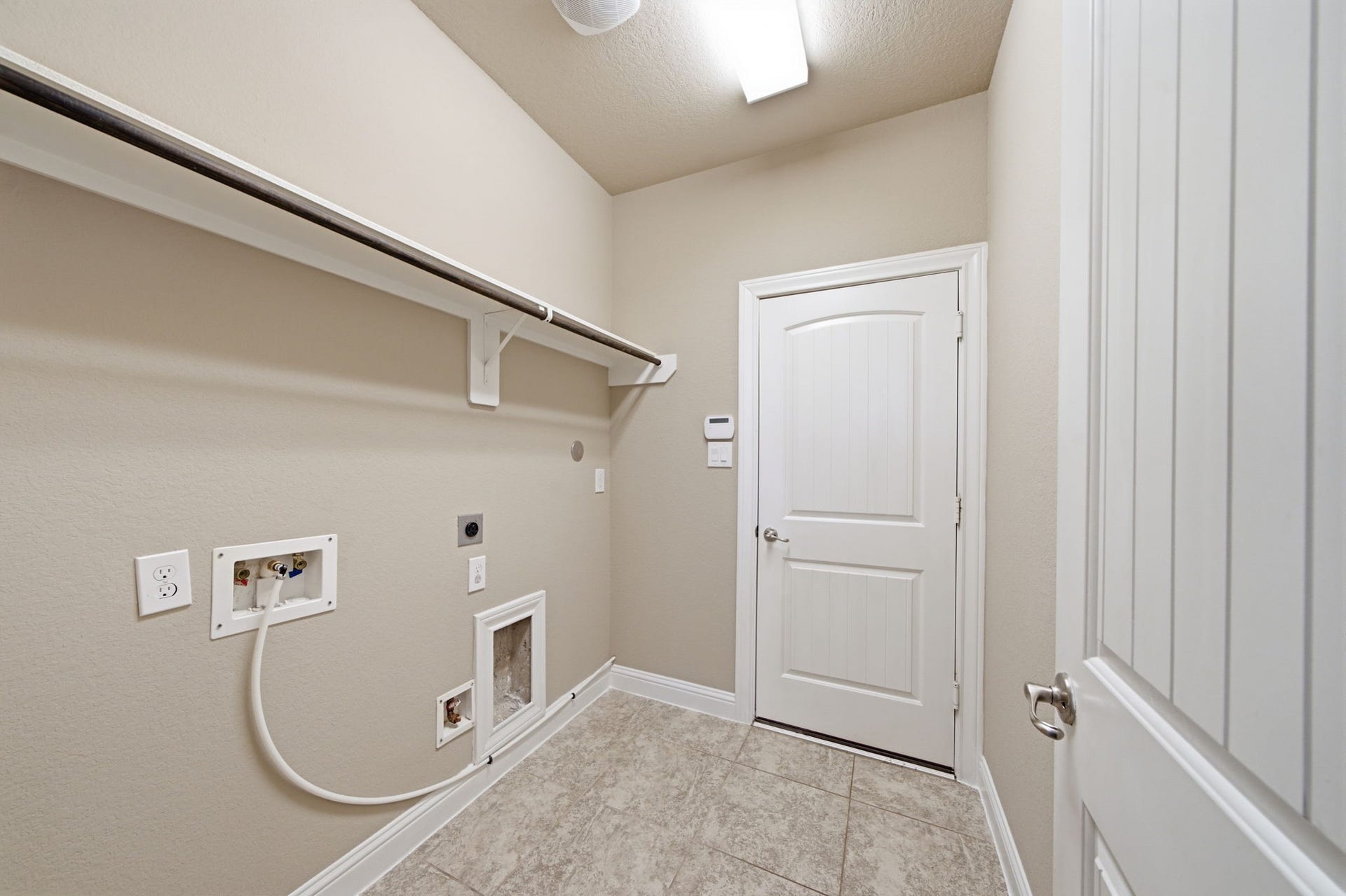 18818 Wichita Trail, Magnolia, TX 77355 Durable tile flooring and neutral wall paint run throughout this utility room, complete with a sturdy hanging rod and a high shelf.