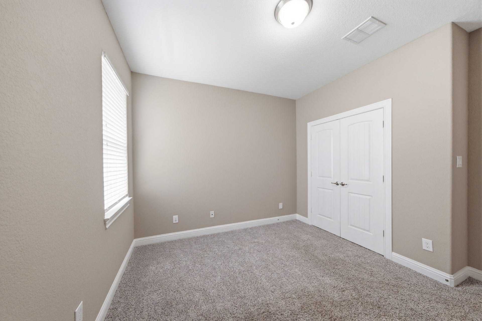 18818 Wichita Trail, Magnolia, TX 77355 Plush carpet flooring and neutral wall paint define this cozy secondary bedroom, which easily adapts to any lifestyle need. A wide window provides natural light, while double doors open to a spacious closet.