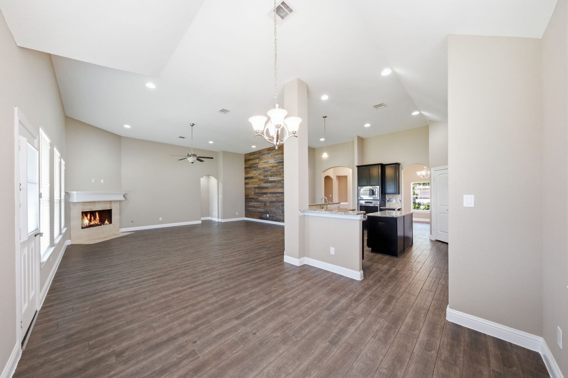 18818 Wichita Trail, Magnolia, TX 77355 Open-concept dining area sits adjacent to the kitchen and living room, showcasing high vaulted ceilings and durable wood-look tile flooring. The central layout offers a seamless flow for entertaining, easily accommodating a table for four to six guests.