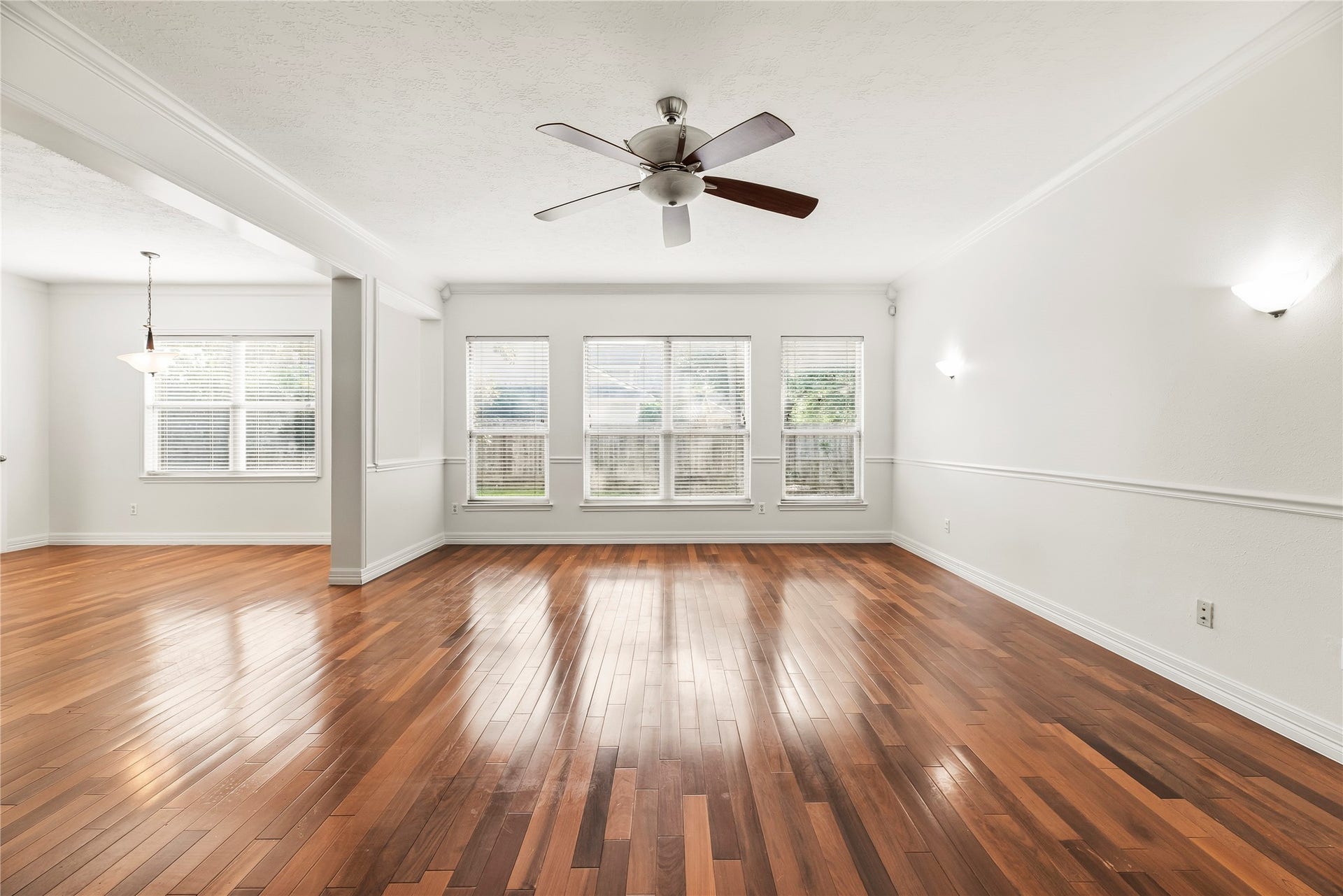 3422 Powell Way, Missouri City, TX 77459 Bright and energizing living room, featuring ceiling fan, beautiful fireplace, wood floors, and fresh paint.