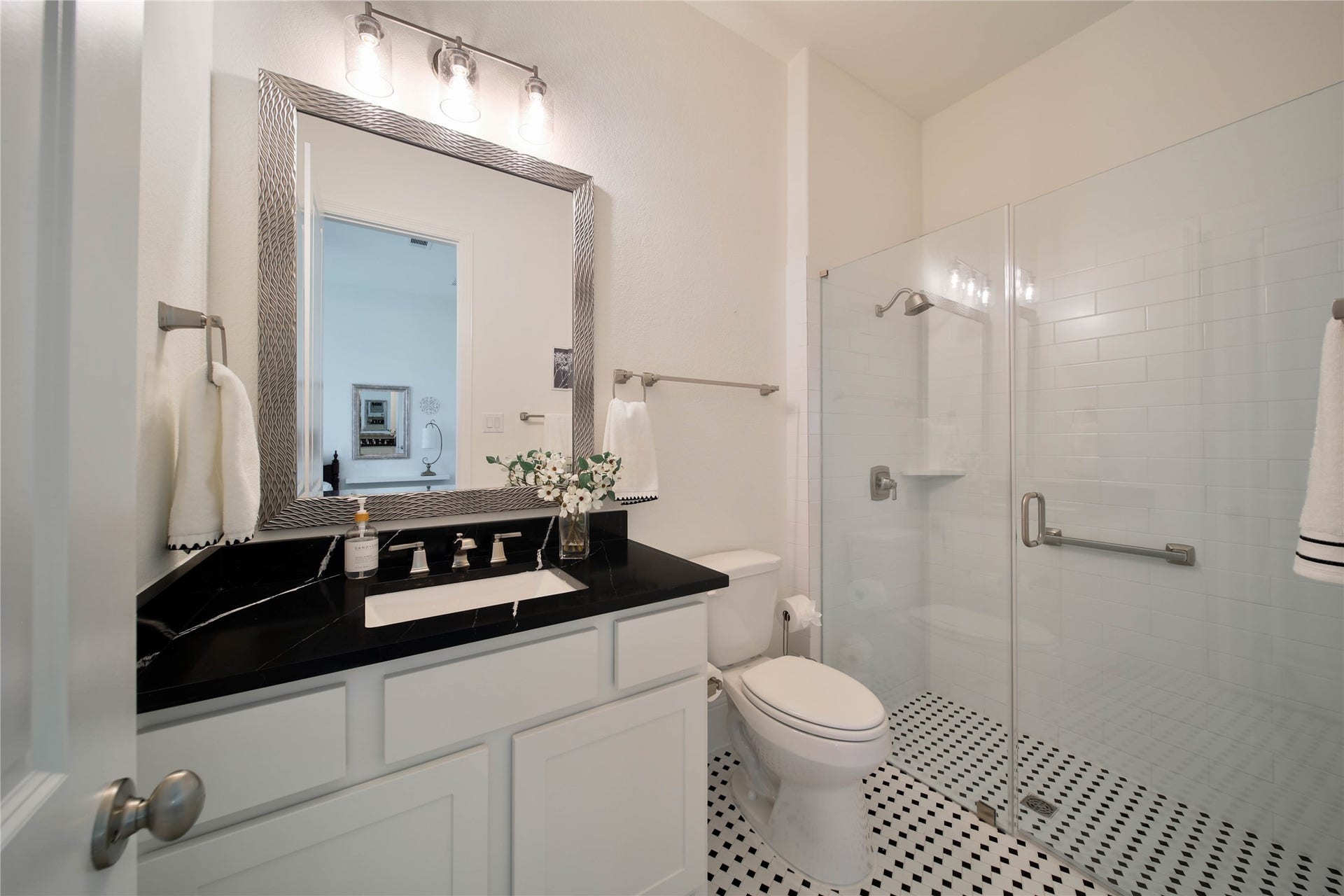 The ensuite bath features a mud-set walk-in shower, striking finishes, and a beautifully designed space that feels both stylish and sophisticated.