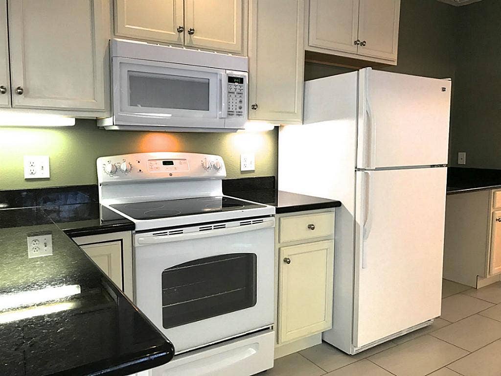 106 Opal Court, Houston, TX 77009 KItchen with range, microwave, and refrigerator. Nice granite counter tops.