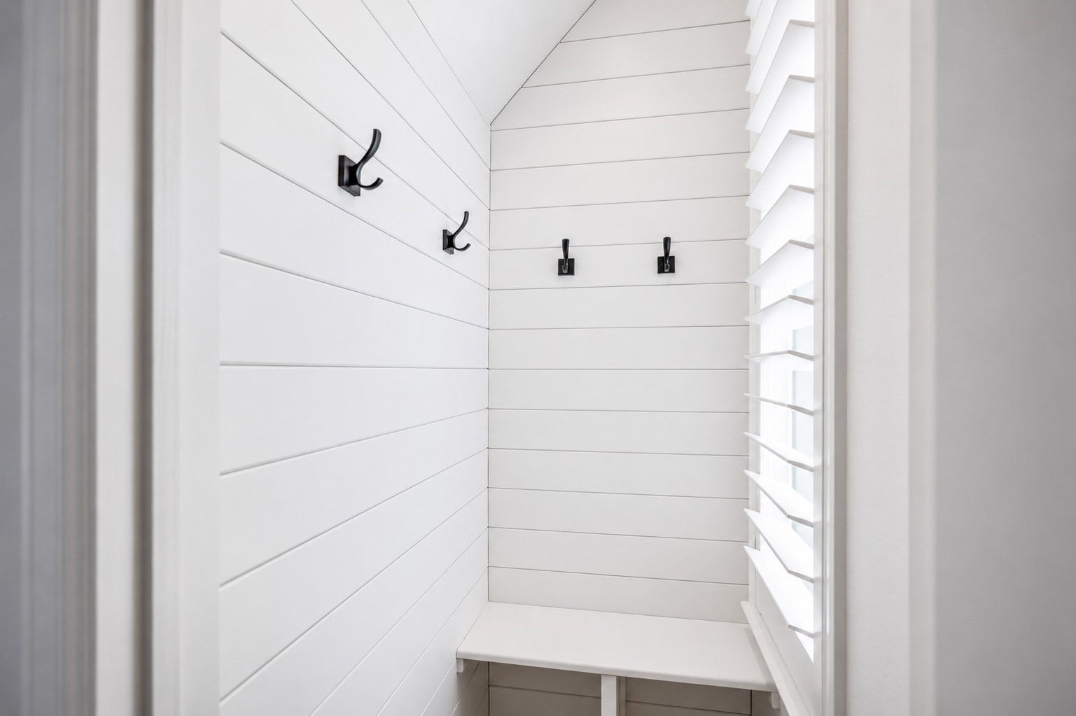 304 Mullins Court, Montgomery, TX 77316 Close to the entry is a mudroom glowing with natural light, with white shiplap walls and a bench.