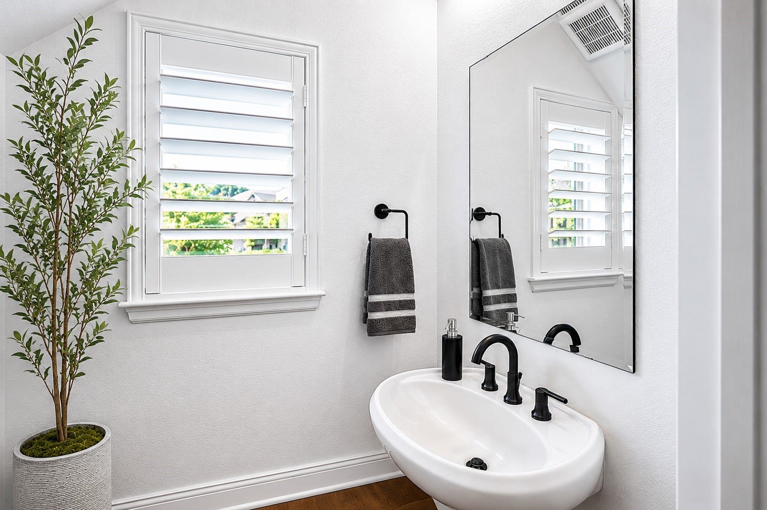 304 Mullins Court, Montgomery, TX 77316 Natural light filters through the plantation shutters and black fixtures add a touch of style to this first-floor half bath.
