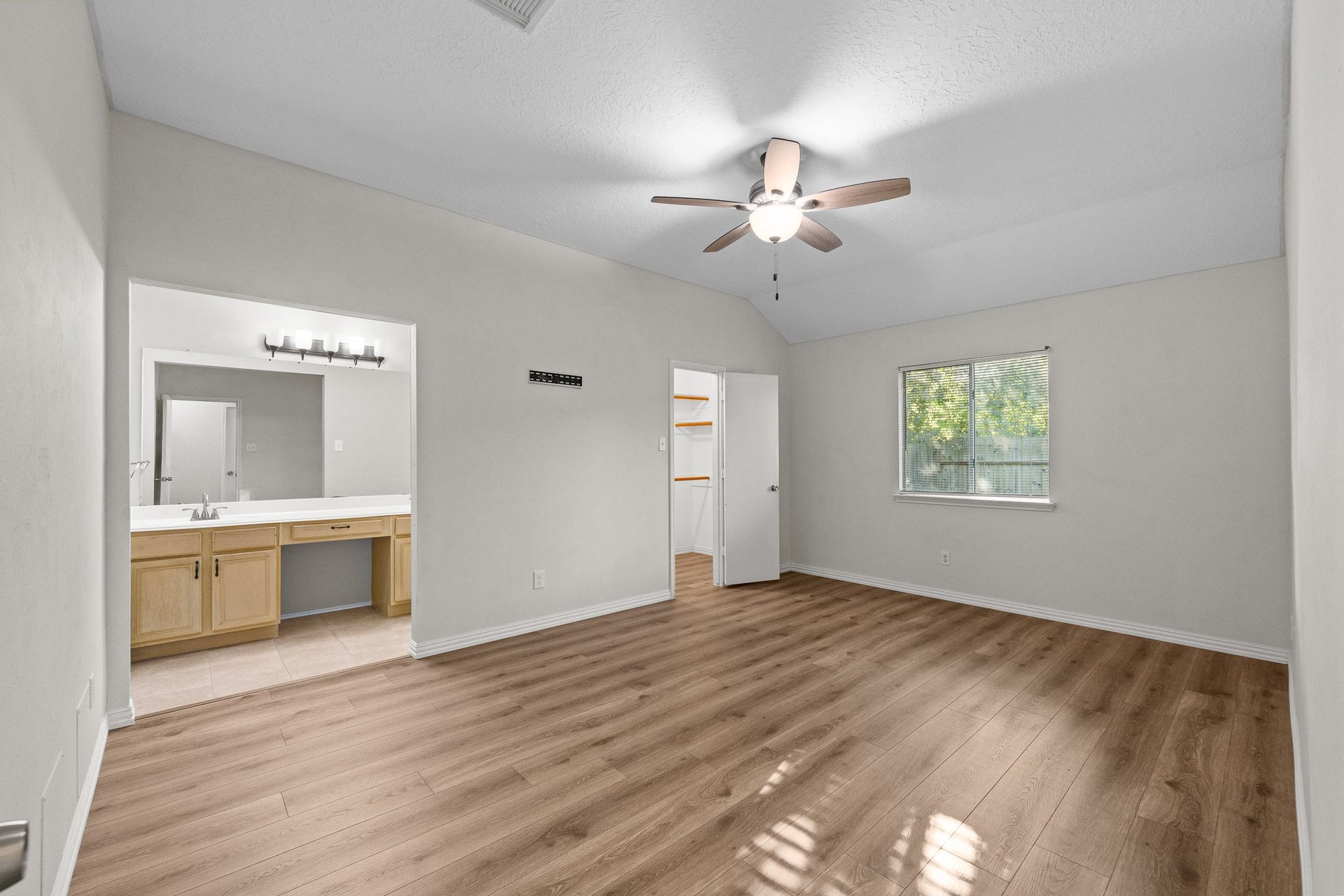 15506 Appleridge Drive, Houston, TX 77489 Spacious bedroom, abundant natural light from a window, and an attached bathroom with dual sinks and ample countertop space.