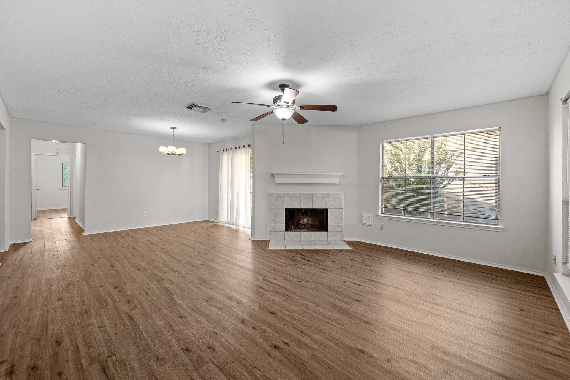 15506 Appleridge Drive, Houston, TX 77489 Spacious living area with beautiful flooring, a cozy fireplace, and ample natural light from large windows, creating an inviting atmosphere.
