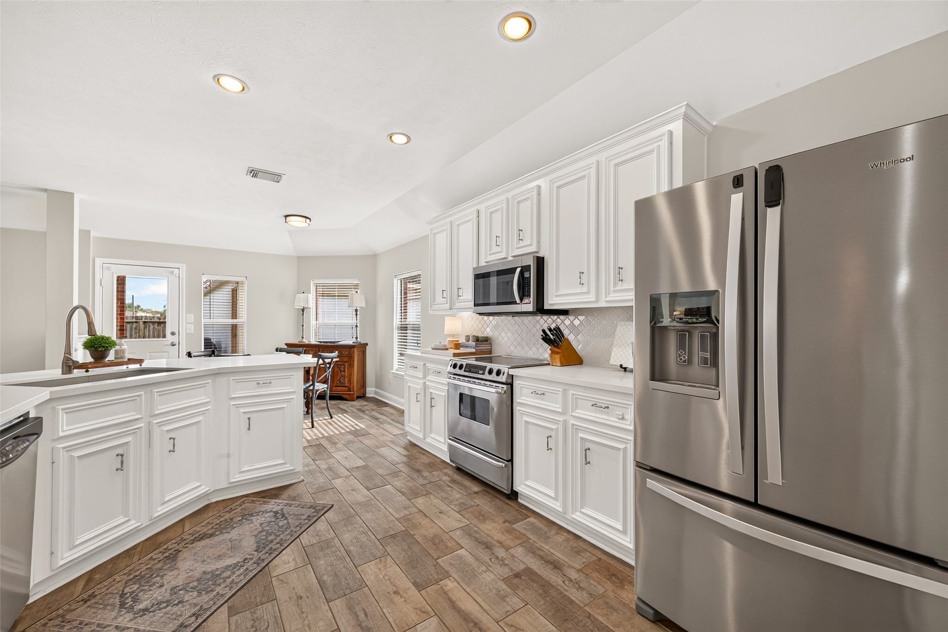 An angled central island with an undermount sink and gooseneck faucet doubles as a convenient prep station and breakfast bar with seating potential.