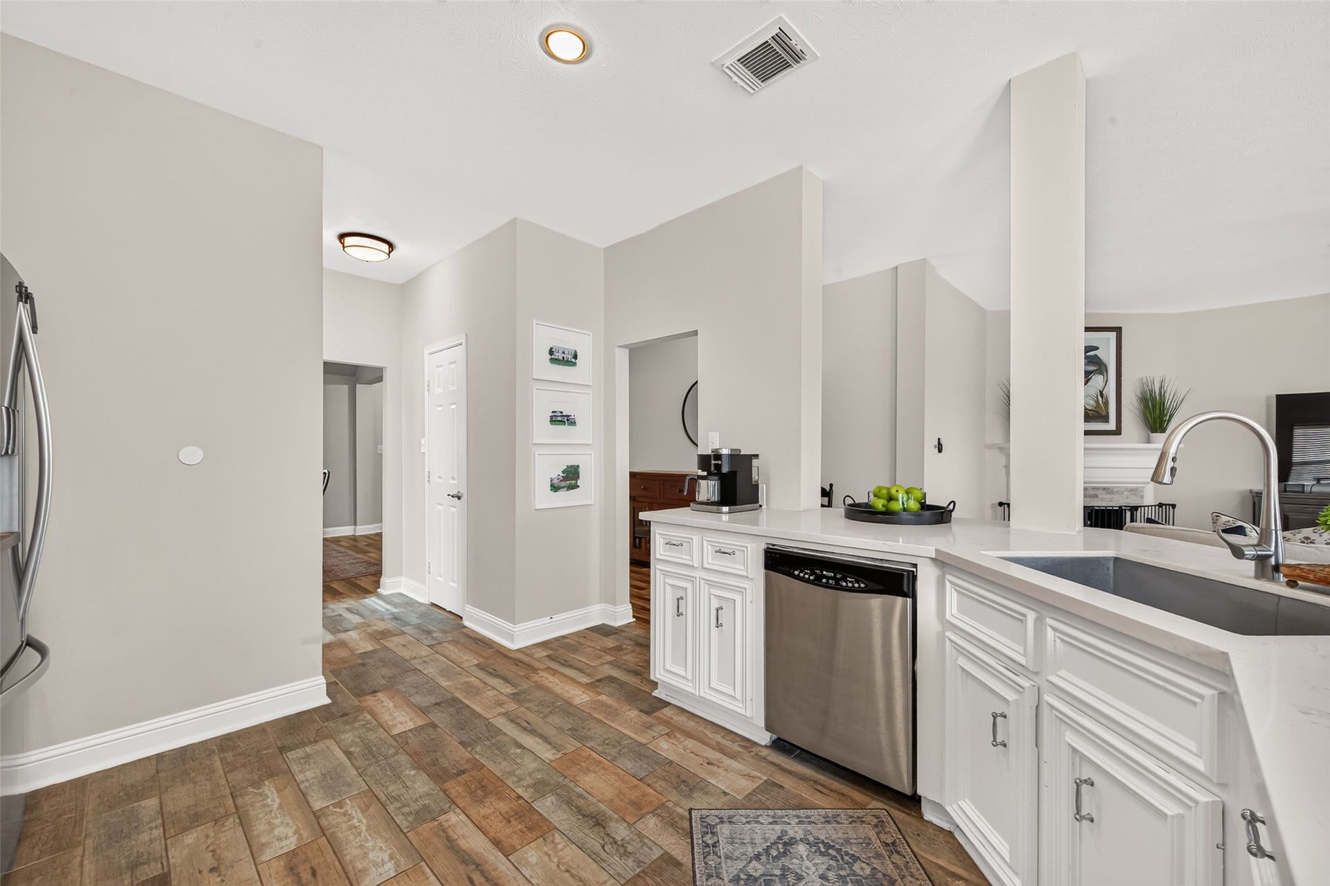 Premium stainless steel appliancesincluding a smooth-top range, over-the-range microwave, and built-in dishwasherare seamlessly integrated into the expansive counter layout.