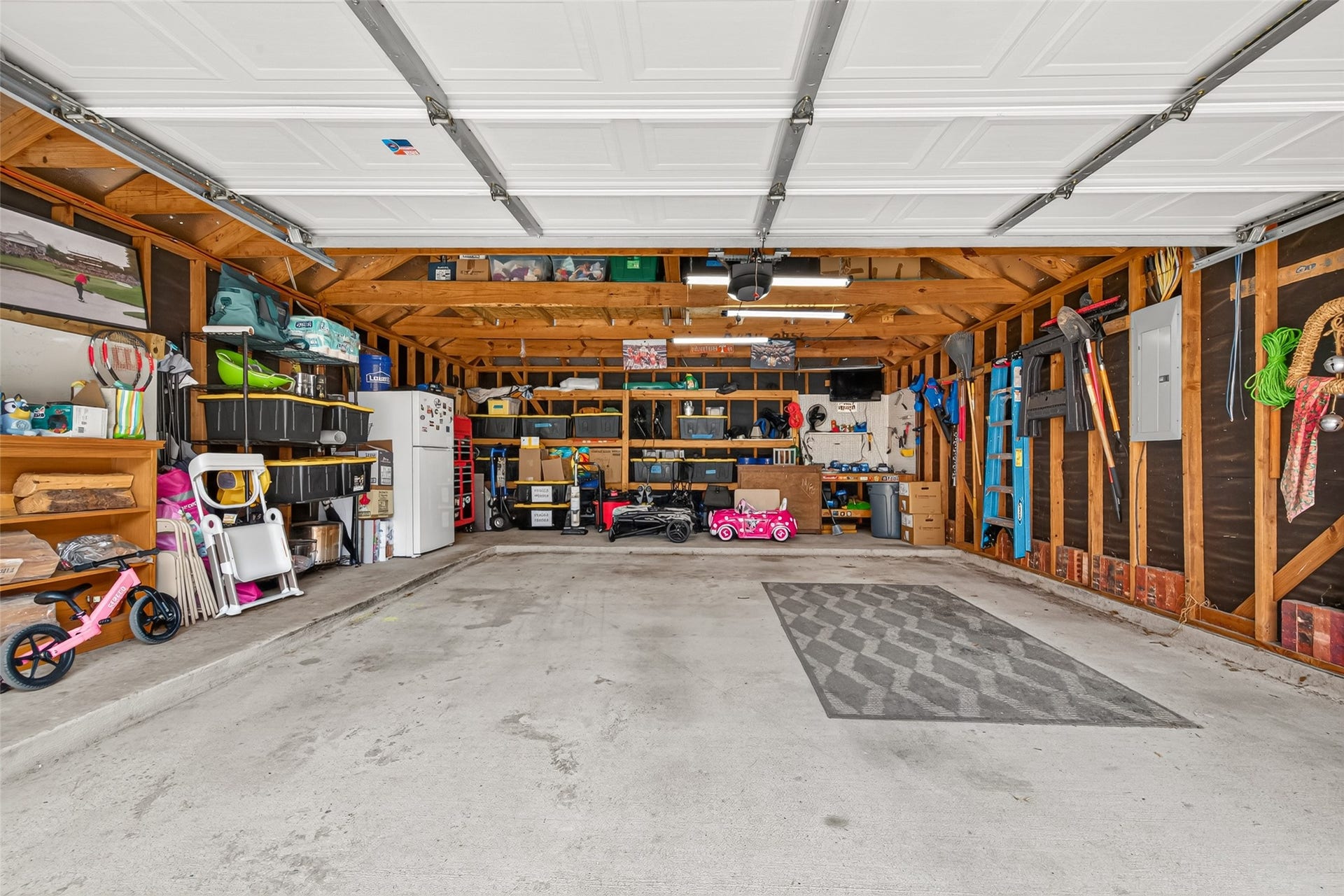This expansive, deep two-car garage provides exceptional space for parking, storage, and home workshop projects. Solid concrete slab flooring extends across the entire bay, offering a durable foundation built to handle heavy vehicles and equipment.