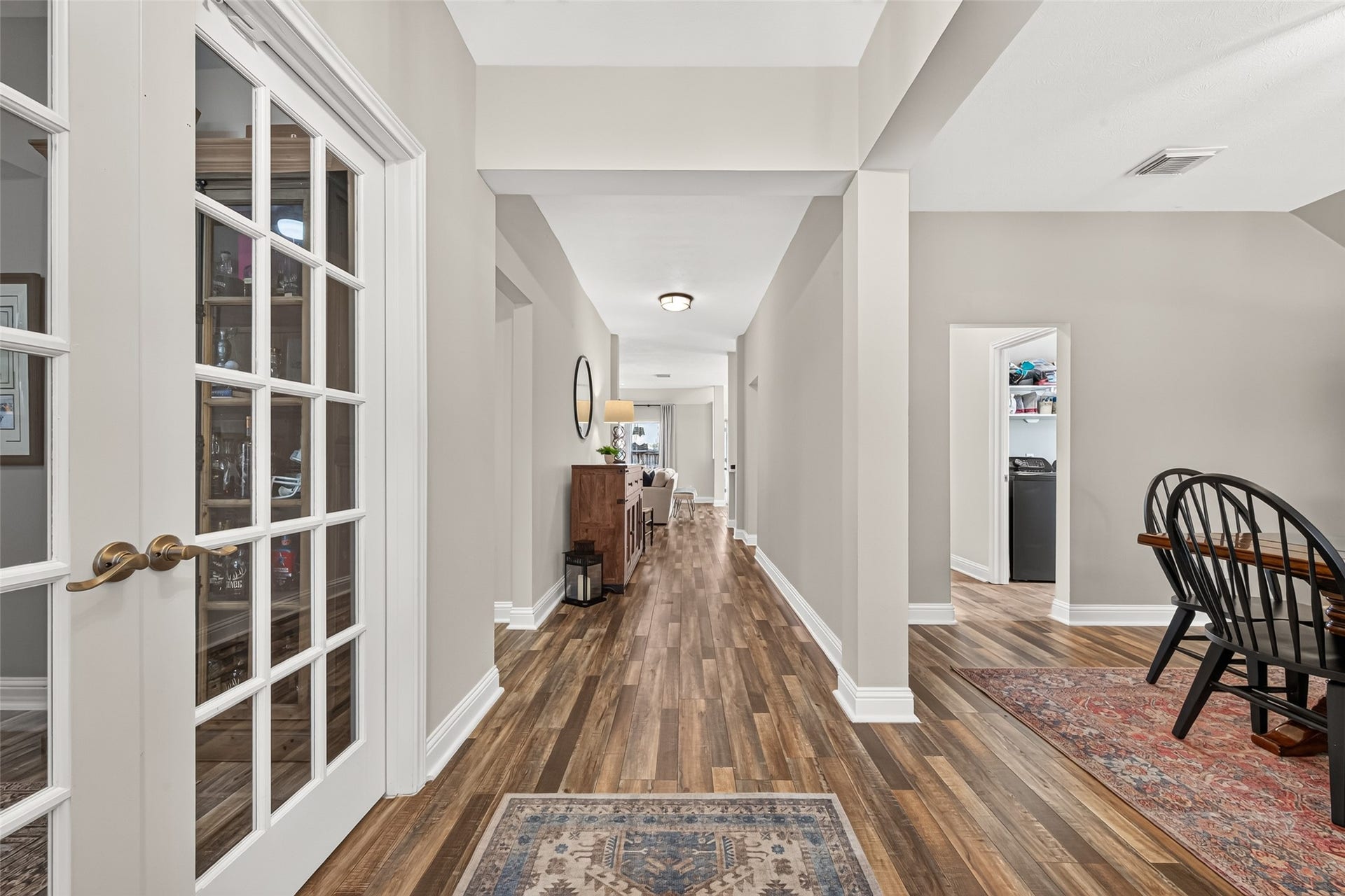 Step inside and immediately experience the warm, sophisticated design of this stunning home's main foyer and hallway. Accentuated by gorgeous multi-tone wood-look plank flooring, bright crisp white baseboards, and a soothing modern neutral palette, this sweeping layout seamlessly connects your primary living spaces with effortless elegance.