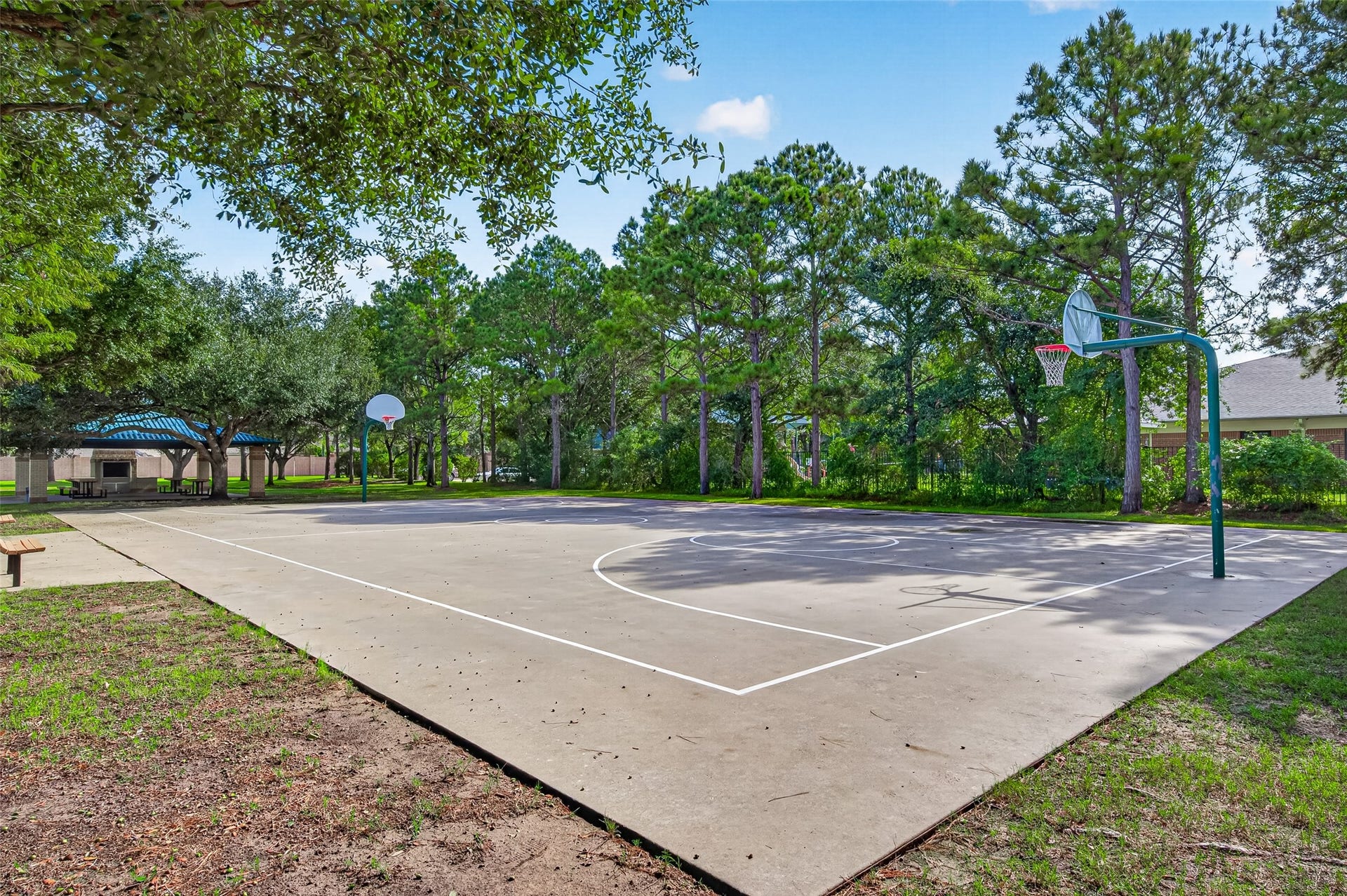 Residents will love the active outdoor lifestyle offered by this full-sized neighborhood basketball court nestled in a serene, park-like setting. Surrounding mature pine and oak trees provide natural shade and a lush backdrop for friendly pickup games, shooting hoops, or evening practice.