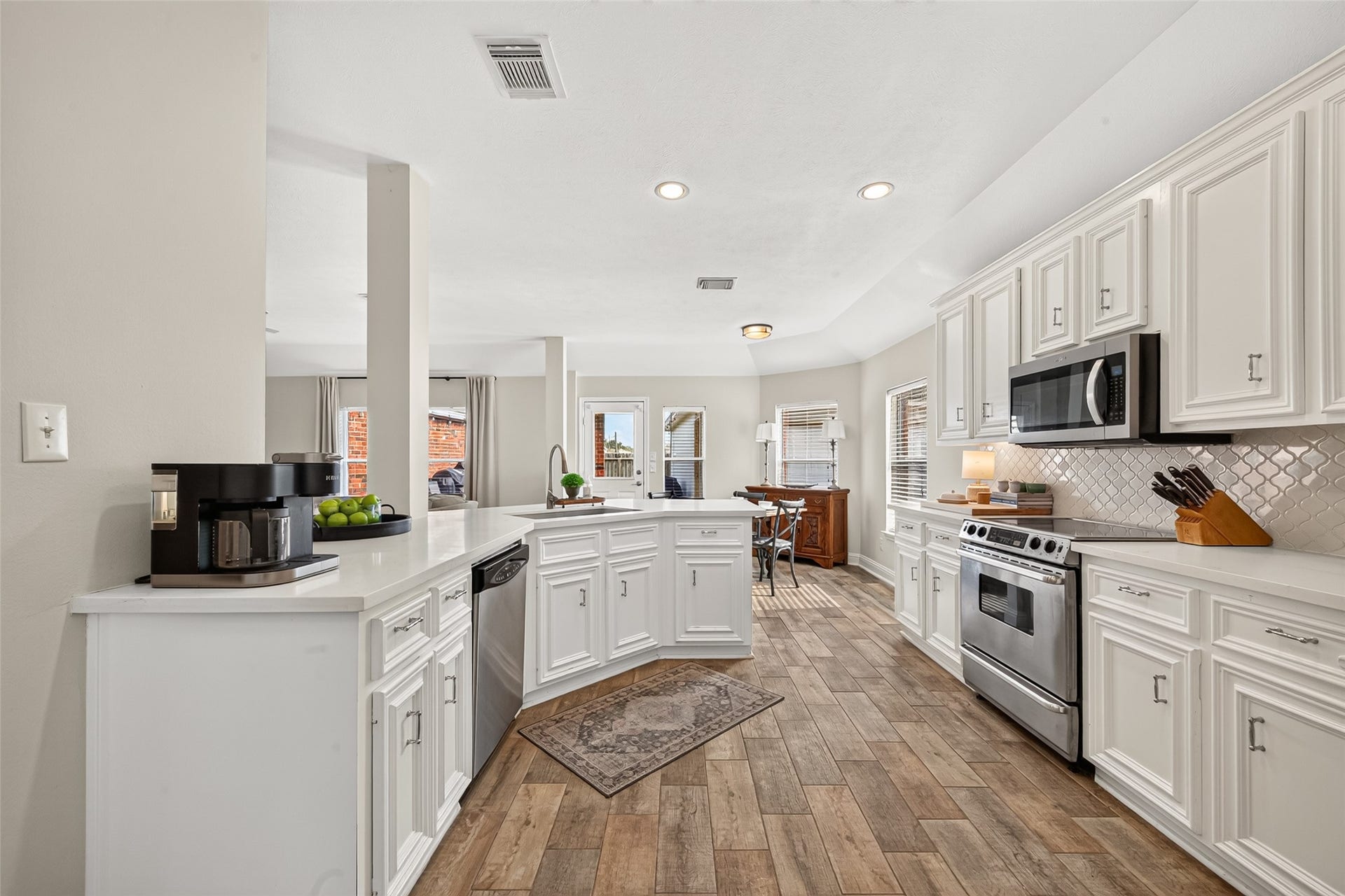 This bright, beautifully appointed kitchen serves as the ideal focal point for both culinary preparation and open-concept entertaining.