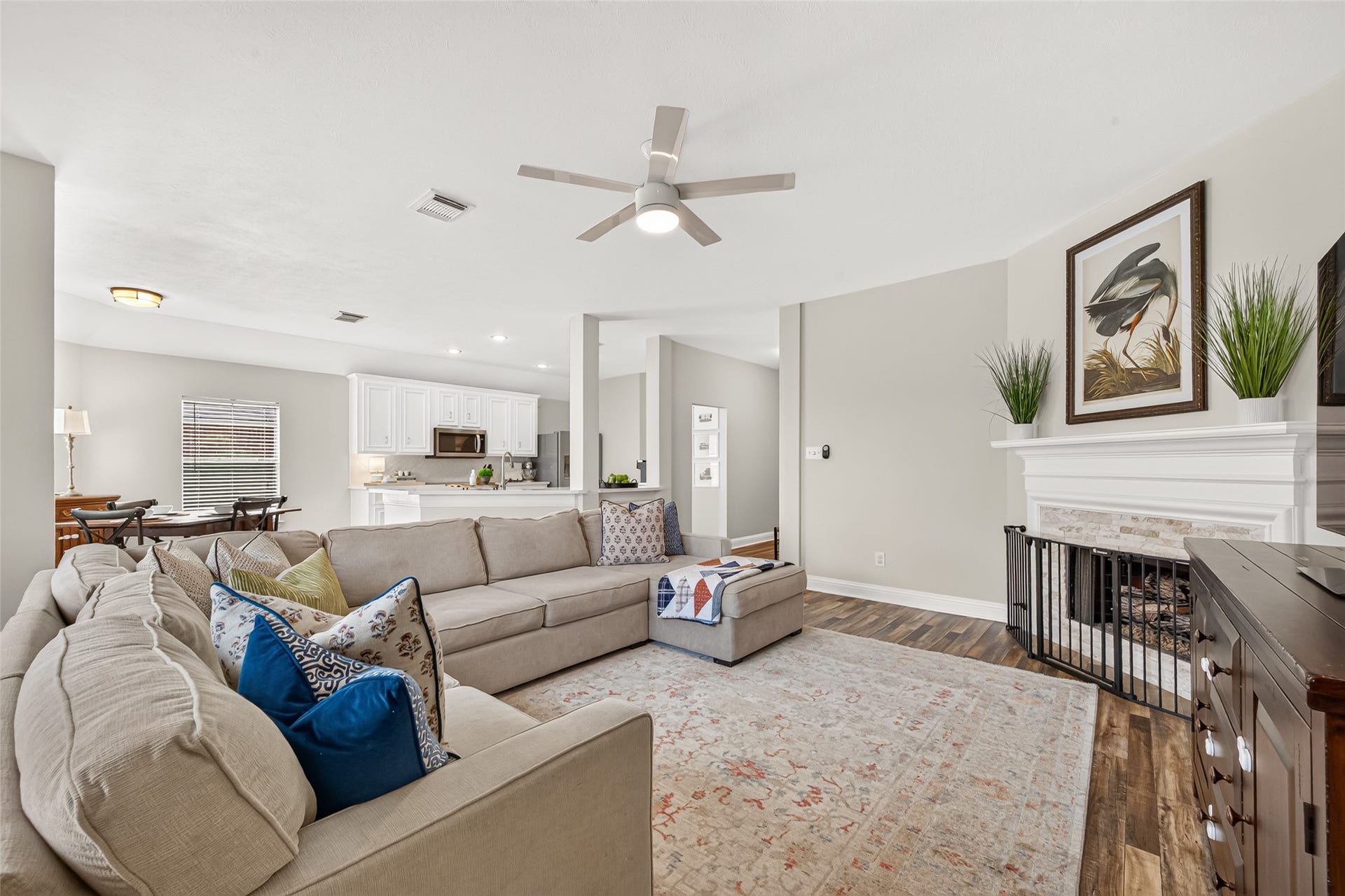 Anchoring the space is a cozy fireplace featuring a stacked stone surround, decorative white mantle, and an intricate fire screen.