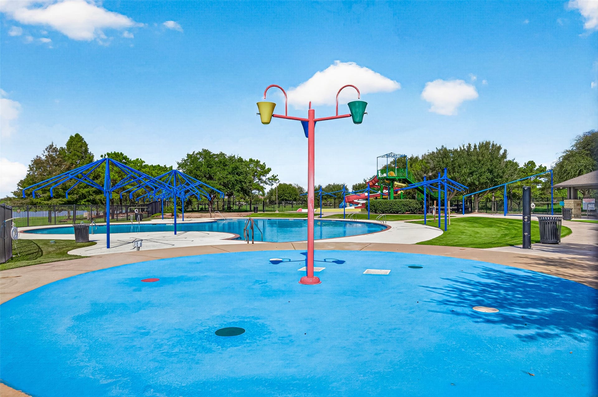 Beat the summer heat at this incredible resort-style community splash pad and water park amenity! Perfect for kids of all ages, the vibrant blue splash pad features interactive water dump buckets and ground sprayers set on a slip-resistant safety surface.
