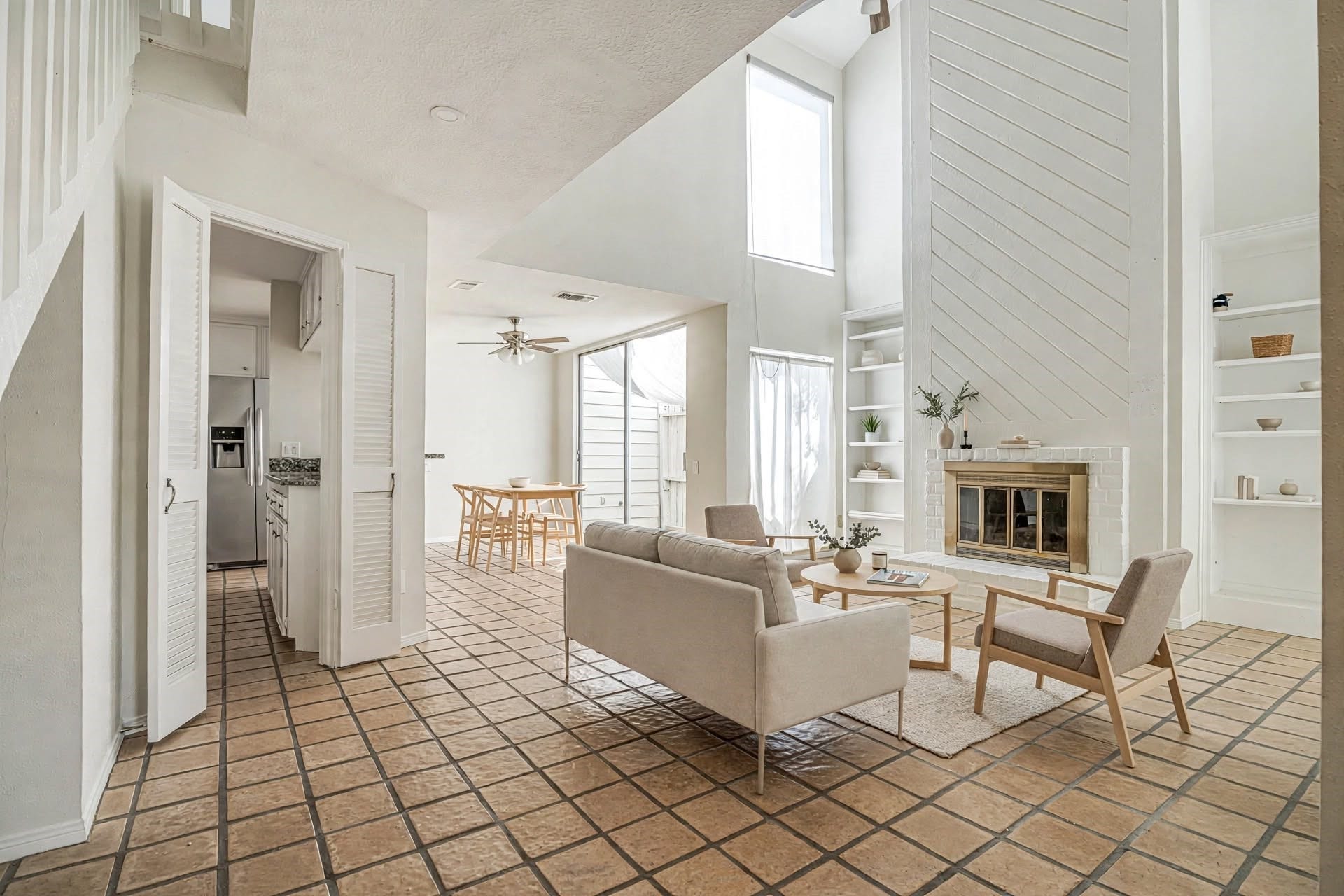 800 Country Place Drive, #1301, Houston, TX 77079 Spacious living area with high ceilings, abundant natural light, and a cozy fireplace, seamlessly connected to a dining space and modern kitchen.