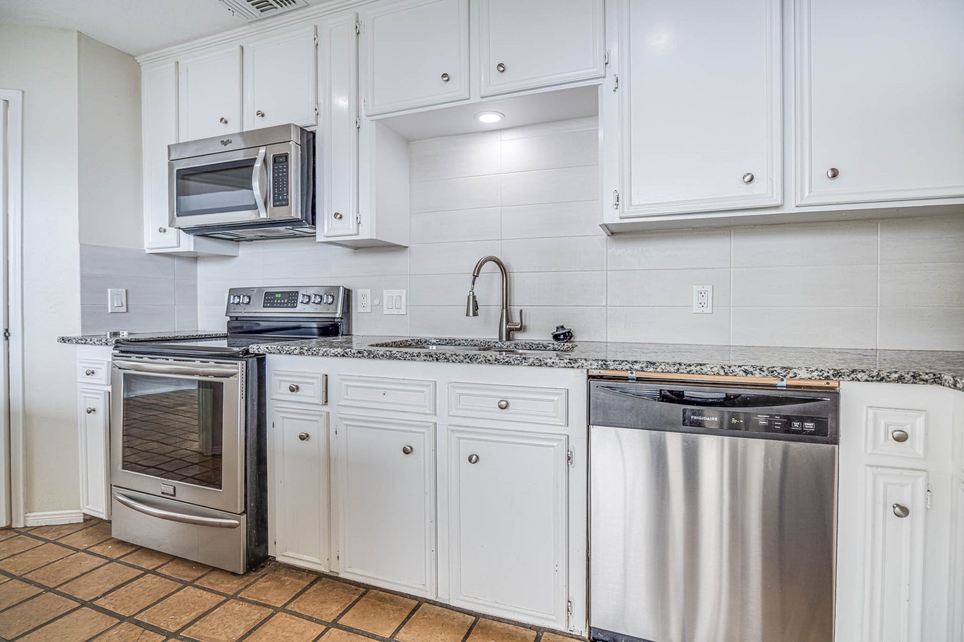 800 Country Place Drive, #1301, Houston, TX 77079 Modern kitchen featuring stainless steel appliances, granite countertops, and elegant white cabinetry.