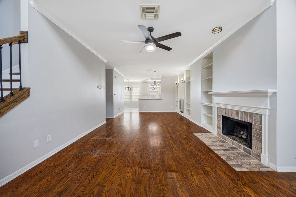 A full view of the open concept main living level. The wood floors, built-ins, and fireplace speak for themselves.
