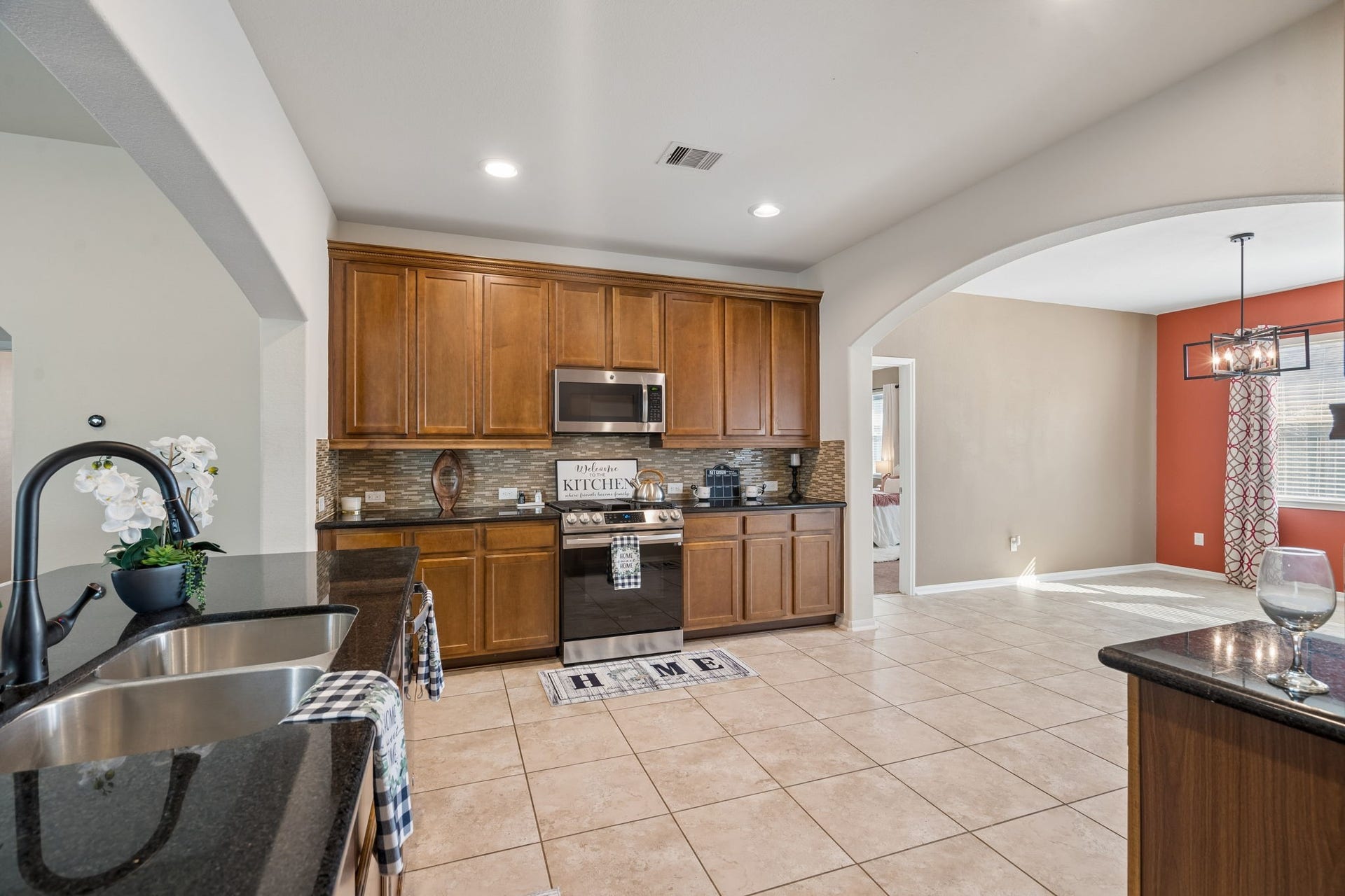 422 Stockport Drive, League City, TX 77573 This generously sized kitchen offers abundant wood cabinetry, granite countertops, stainless steel appliances, a decorative tile backsplash and recessed lighting