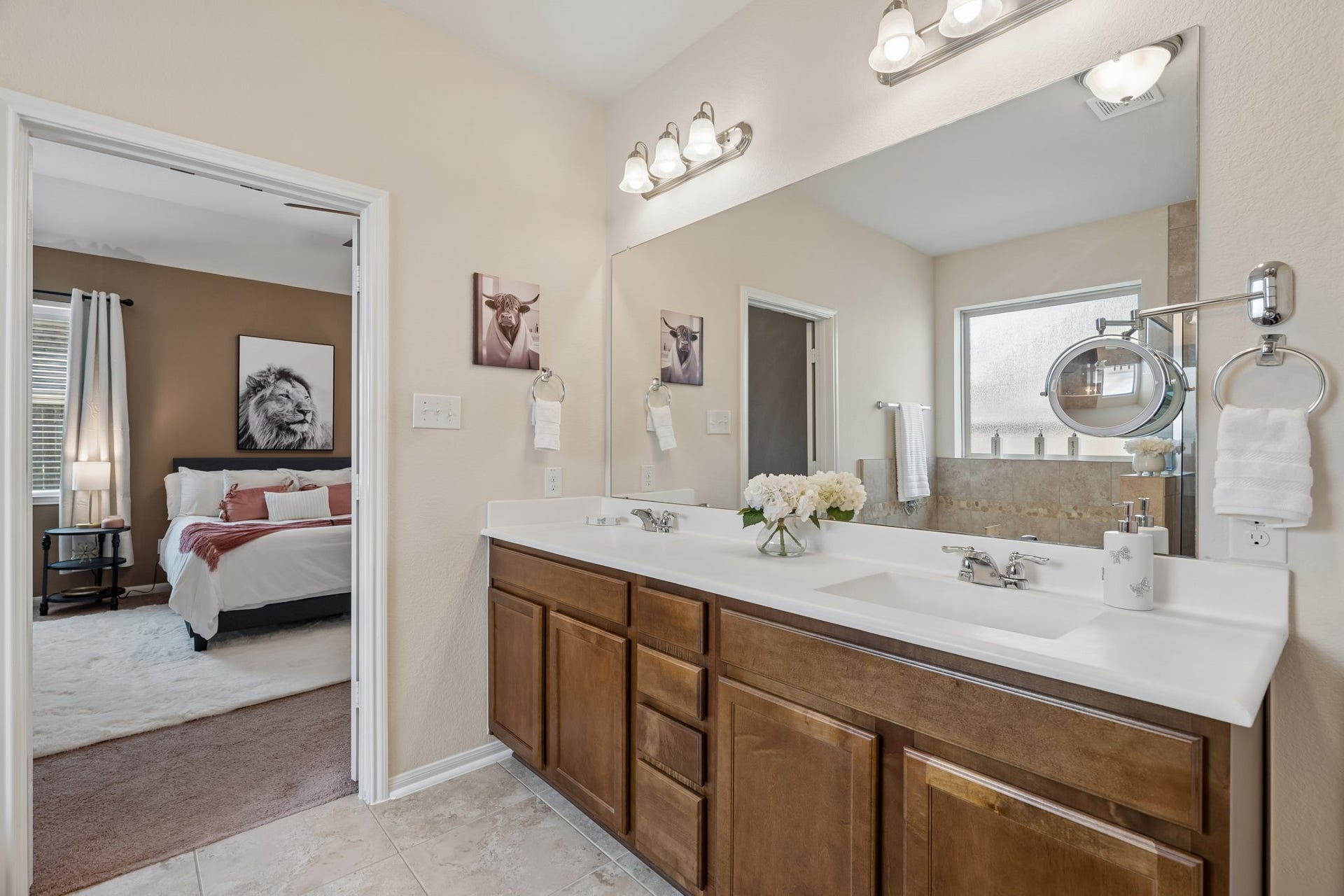 422 Stockport Drive, League City, TX 77573 The primary bathroom features an extended dual-sink vanity with generous countertop space, warm wood cabinetry and a large wall-to-wall mirror