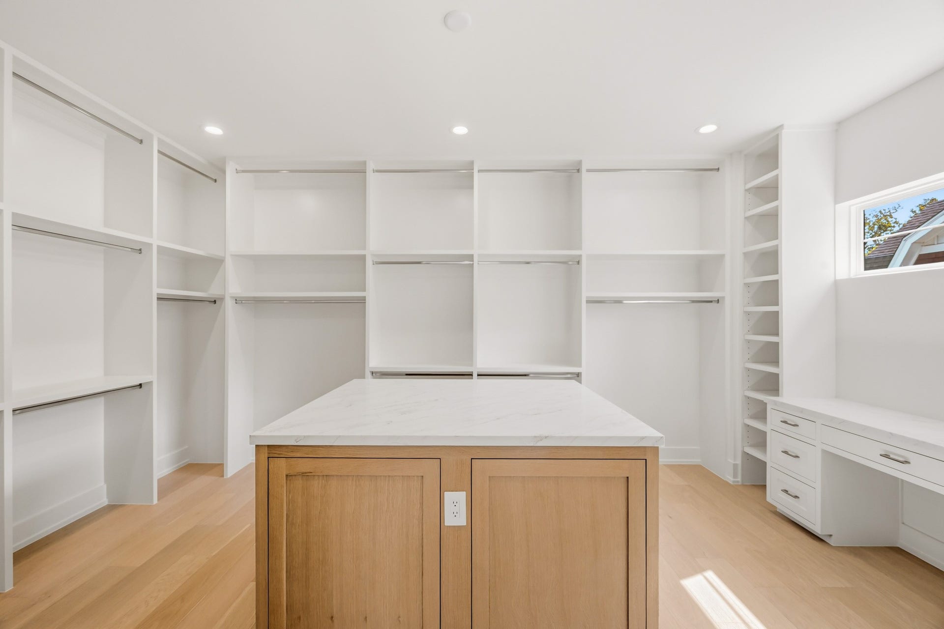 The master closet enjoys an island, makeup vanity, and tons of built-ins!