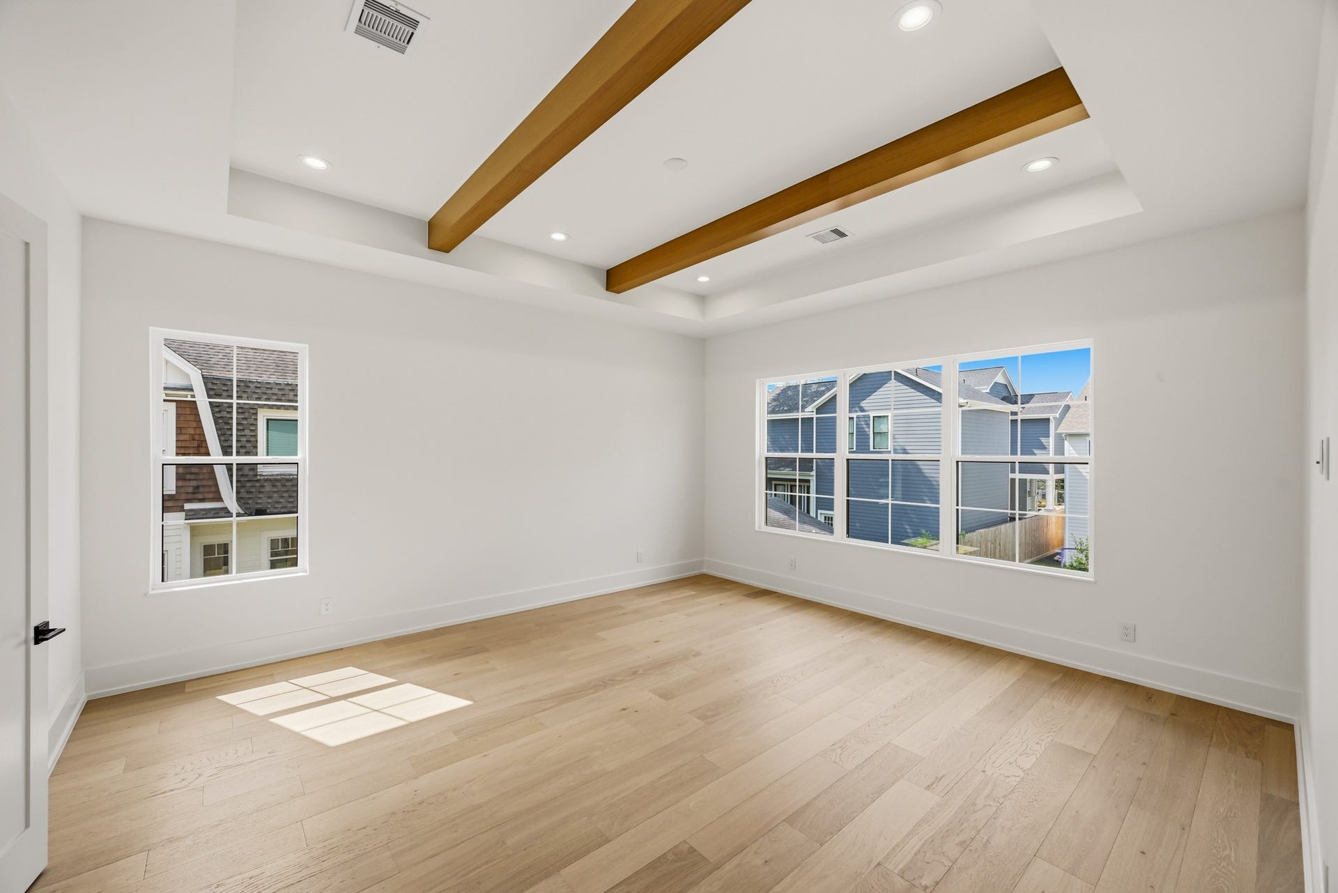 The master suite offers tray ceilings, wood beams, and a view of the backyard!