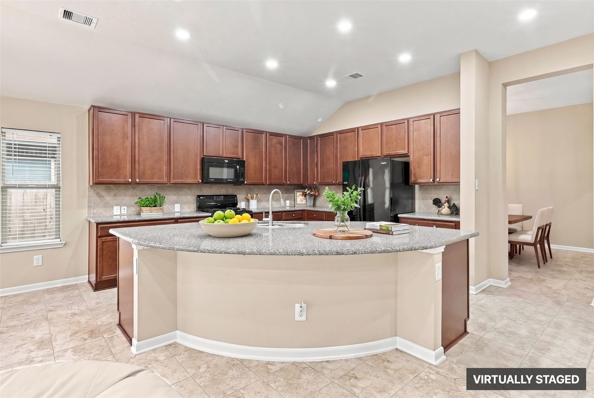 24015 Orange Orchard Lane, Katy, TX 77493 Virtually staged. The island's sweep wraps the kitchen's working side, with recessed lighting overhead and stained cabinetry running the full length of the walls.