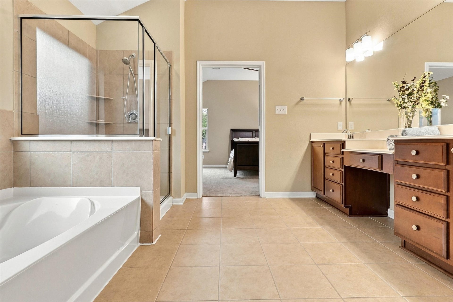 24015 Orange Orchard Lane, Katy, TX 77493 The primary bath pairs a soaking tub with a separate glass-enclosed shower, so mornings run on two schedules without a wait.