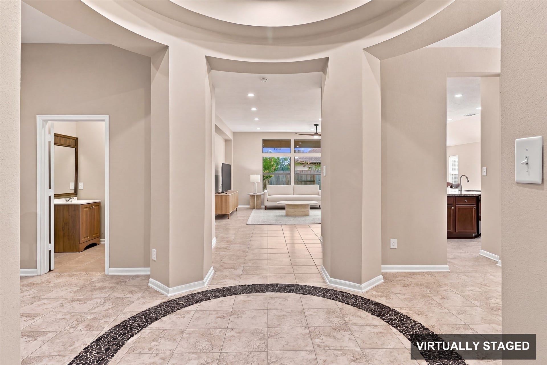 24015 Orange Orchard Lane, Katy, TX 77493 Virtually staged. From the foyer the sightline carries through to the family room and the backyard windows, with the kitchen and a bath just off the gallery.