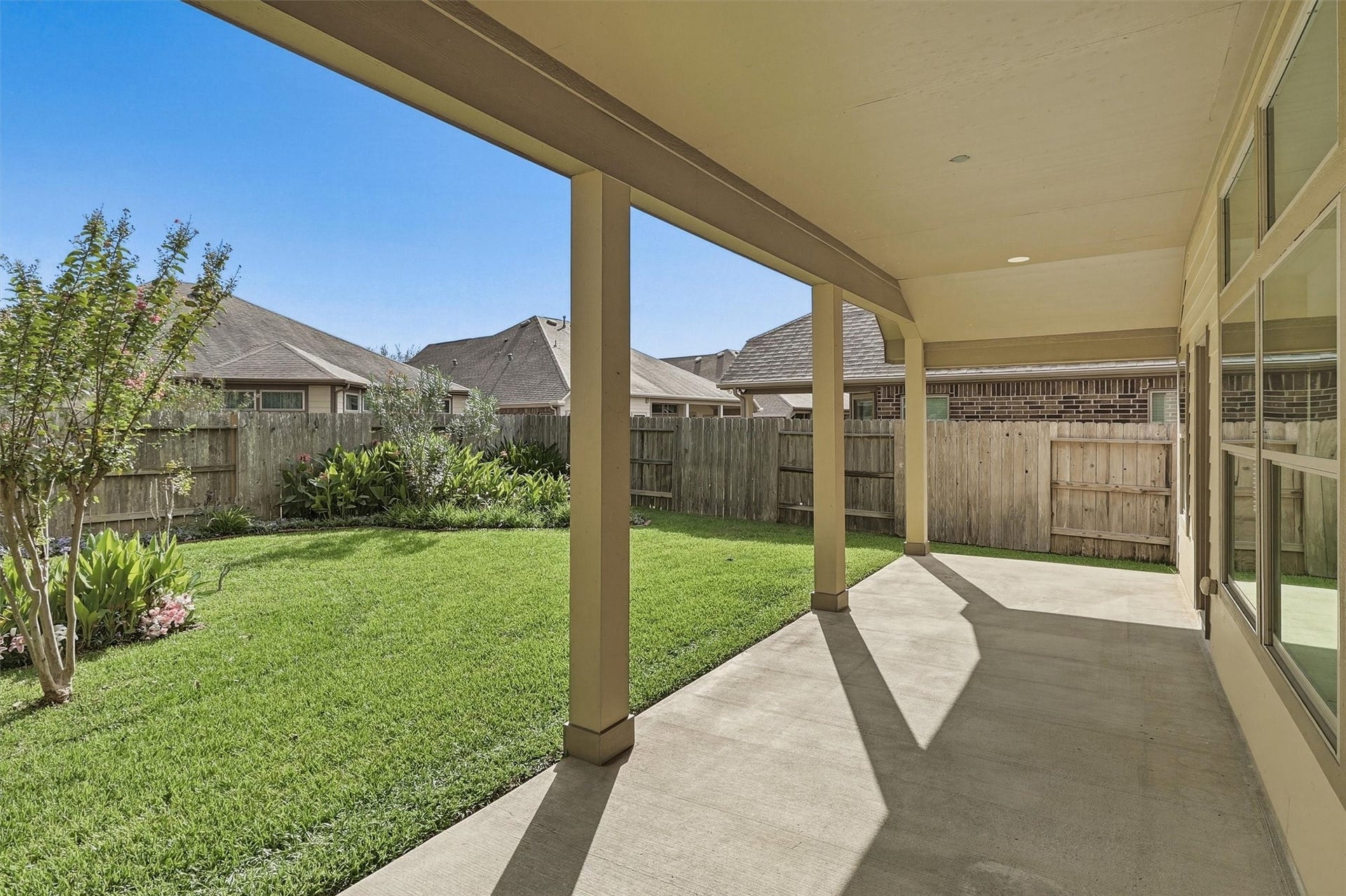 24015 Orange Orchard Lane, Katy, TX 77493 Columns frame the yard from under the patio roof, with room for an outdoor dining set and grill.