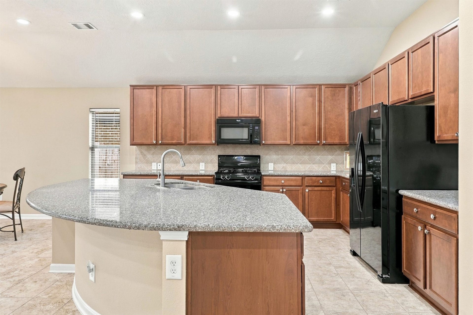 24015 Orange Orchard Lane, Katy, TX 77493 A curved granite island keeps the cook facing the family room instead of the wall, with plenty of counter for serving.