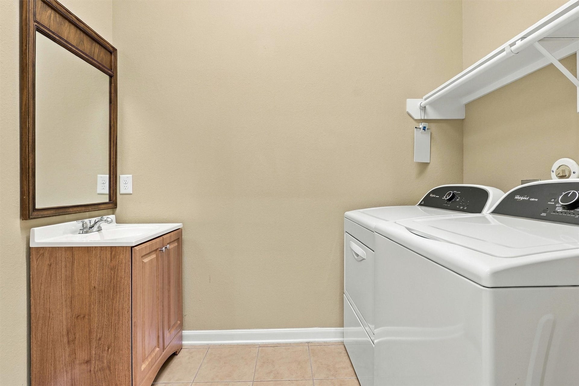 24015 Orange Orchard Lane, Katy, TX 77493 Laundry room with a utility sink and hanging rod - washer and dryer hookups away from the living areas.
