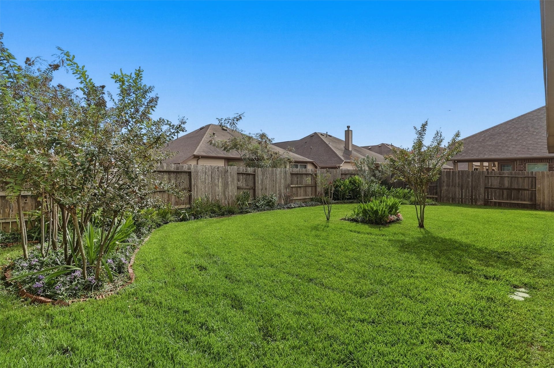 24015 Orange Orchard Lane, Katy, TX 77493 Mature crape myrtles along the fence line soften the backyard and add shade along the edges of the lawn.