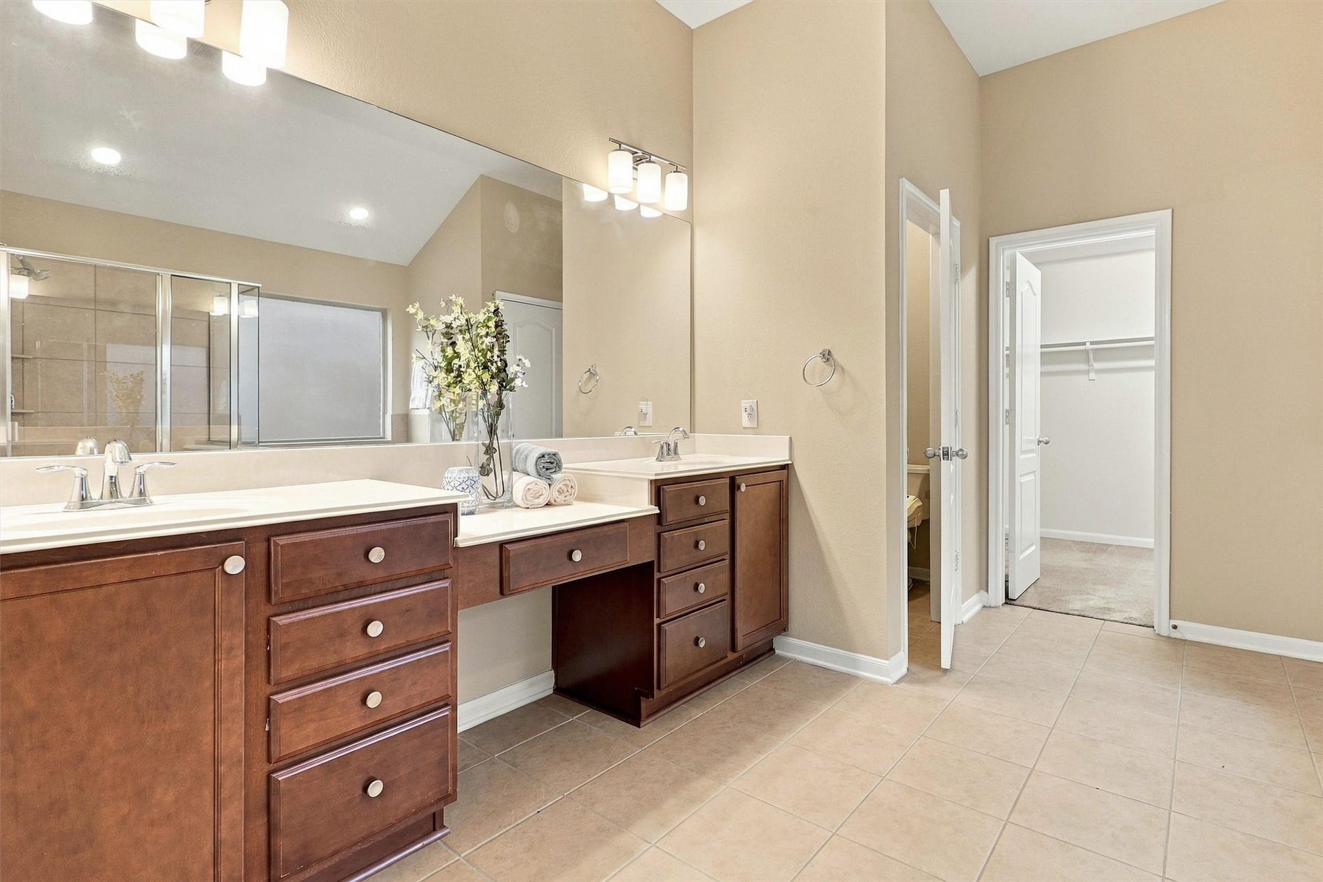 24015 Orange Orchard Lane, Katy, TX 77493 Dual vanities flank a built-in makeup desk, with a walk-in closet opening right off the bath.