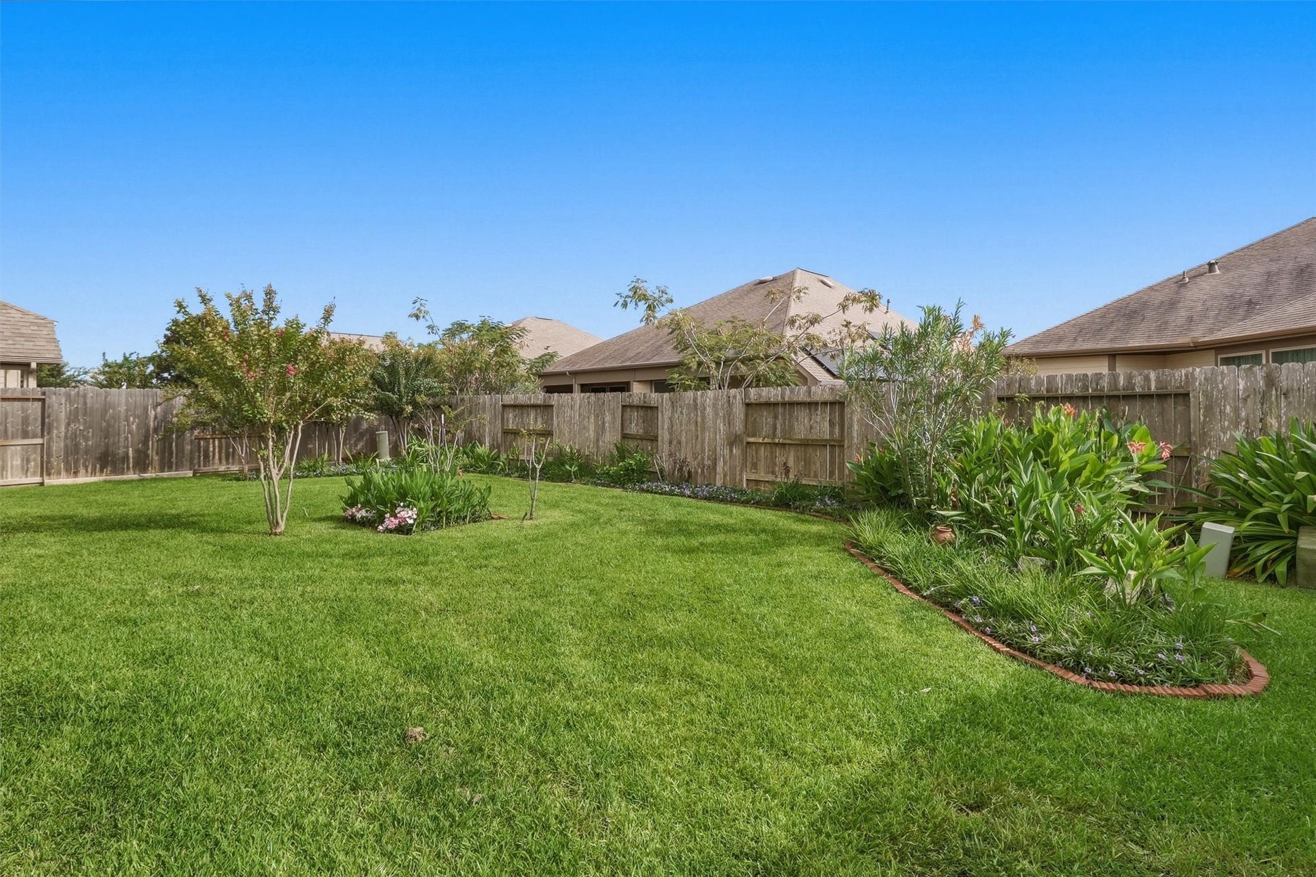 24015 Orange Orchard Lane, Katy, TX 77493 Designed landscaping with irrigation front and back - curved, edged beds and flowering crape myrtles bring color to the yard.