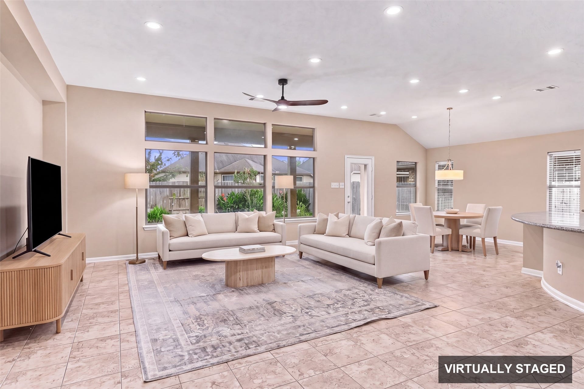 24015 Orange Orchard Lane, Katy, TX 77493 Virtually staged. The family room rises to a high ceiling with a row of transom windows over the backyard, pulling natural light deep into the room.