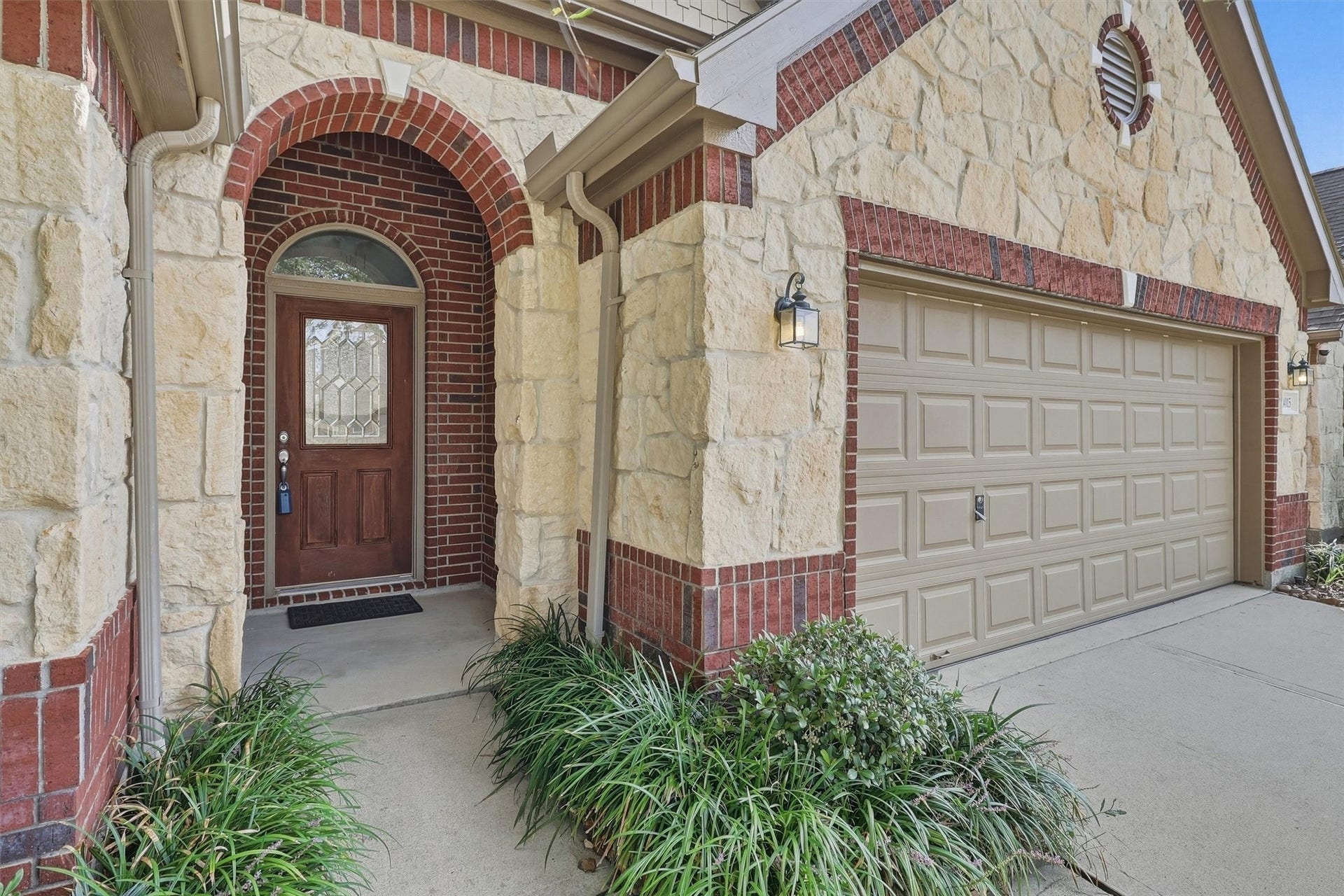 24015 Orange Orchard Lane, Katy, TX 77493 An arched brick entry frames a glass-inset front door, setting the tone for the rotunda foyer just inside.