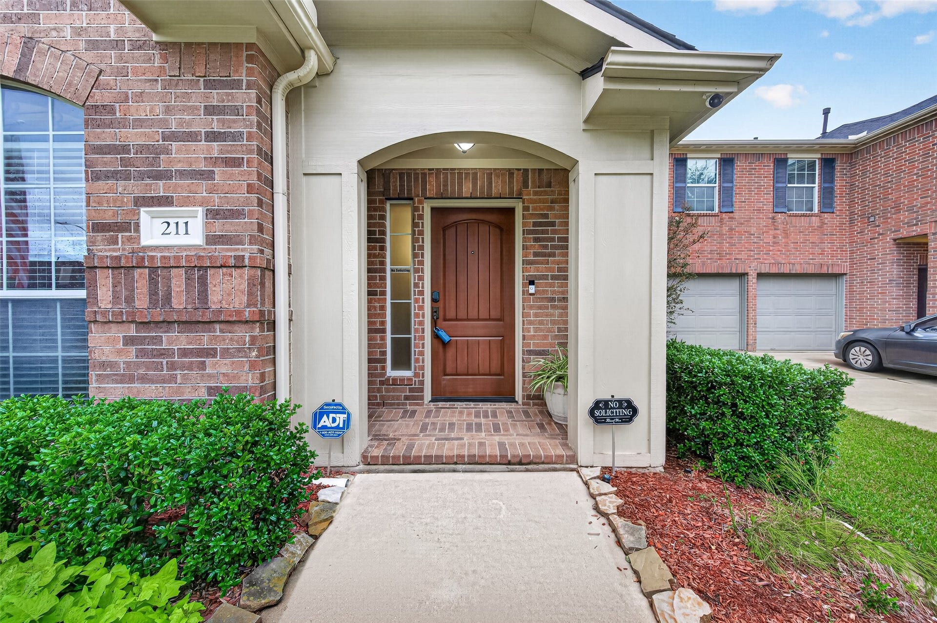211 Little Summer Drive, Rosenberg, TX 77469 Covered arched entry, with an upgraded fiberglass front door, brick front porch and exterior lighted security cameras.