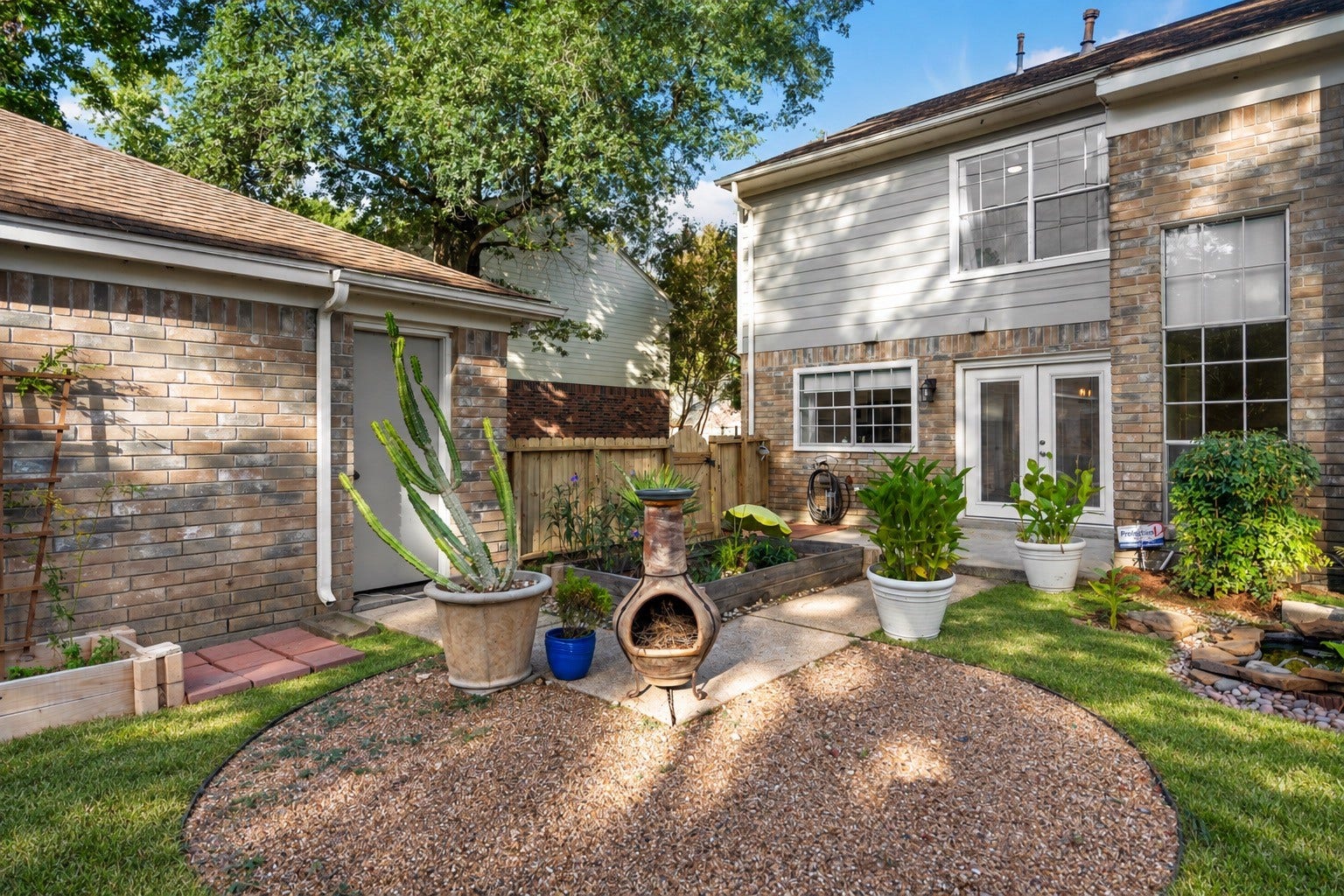 2631 Woodsboro Drive, Spring, TX 77388 Charming backyard oasis featuring a cozy patio area, lush greenery, and a quaint water feature, perfect for relaxation and outdoor entertaining.