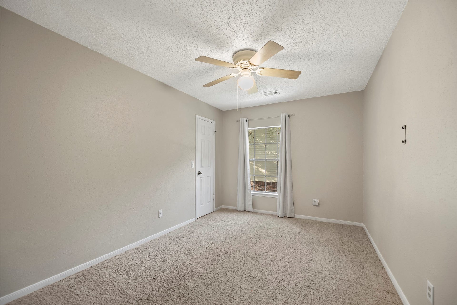 2631 Woodsboro Drive, Spring, TX 77388 Bright and airy bedroom with neutral tones, featuring a ceiling fan.
