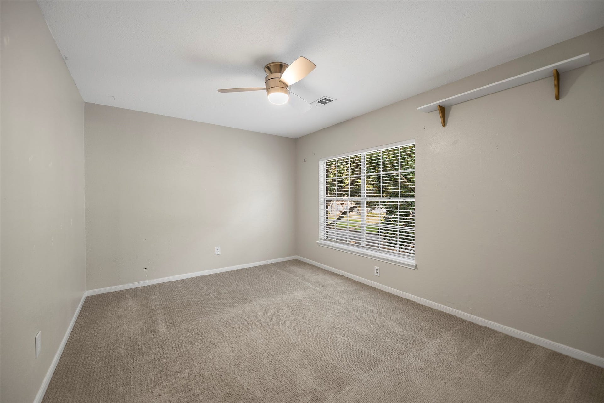 2631 Woodsboro Drive, Spring, TX 77388 Bright and airy bedroom, a large window with lush outdoor views, and a modern ceiling fan for comfort.