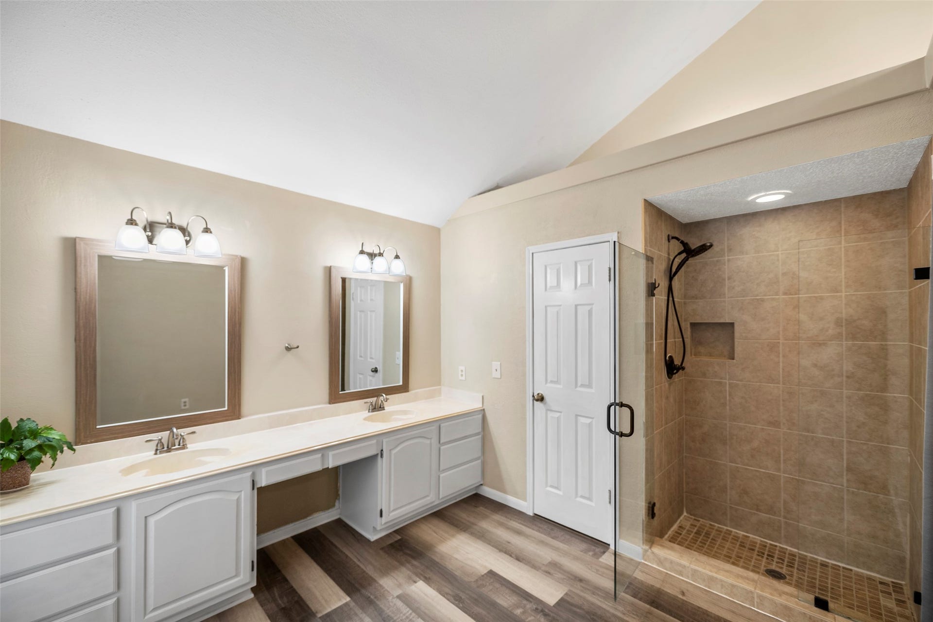 2631 Woodsboro Drive, Spring, TX 77388 Spacious bathroom featuring a double vanity with elegant lighting, a large walk-in shower with modern tiling, and stylish wood-look flooring.