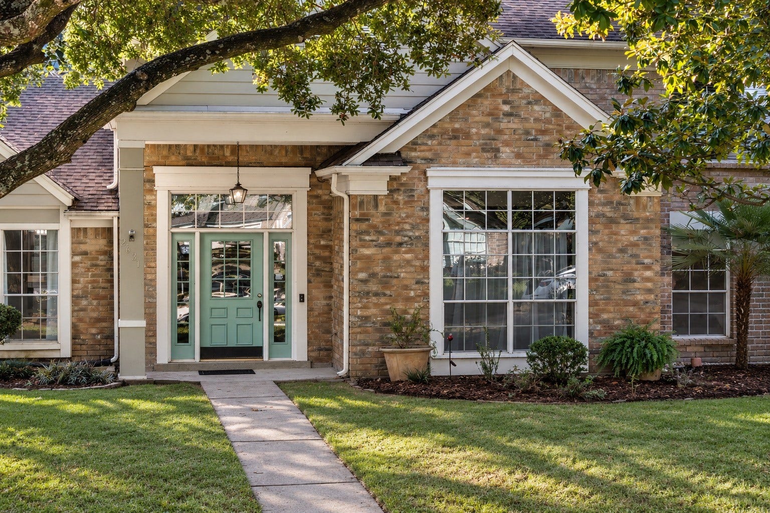 2631 Woodsboro Drive, Spring, TX 77388 The welcoming mint-green front door, framed by large windows and shaded by mature trees, offering great curb appeal.