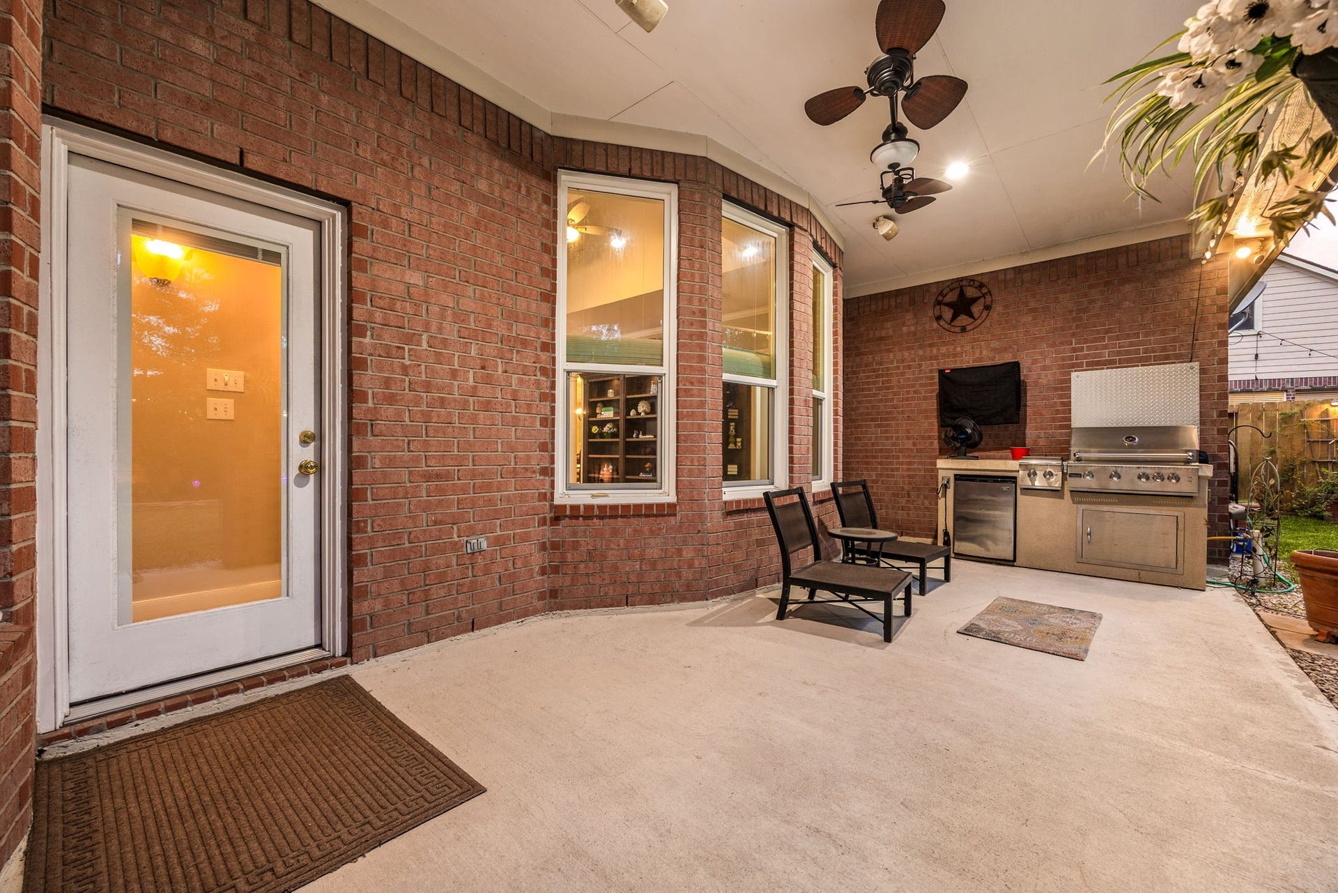4110 Garden Cove Court, Katy, TX 77494 This impressive covered patio functions as a true extension of the home, featuring dual ceiling fans, a mounted television, and a premium built-in outdoor kitchen with a gas grill and mini-fridge. Surrounded by classic brick architecture and looking out to a spacious backyard, it is the absolute perfect setting for weekend barbecues and game-day entertaining.