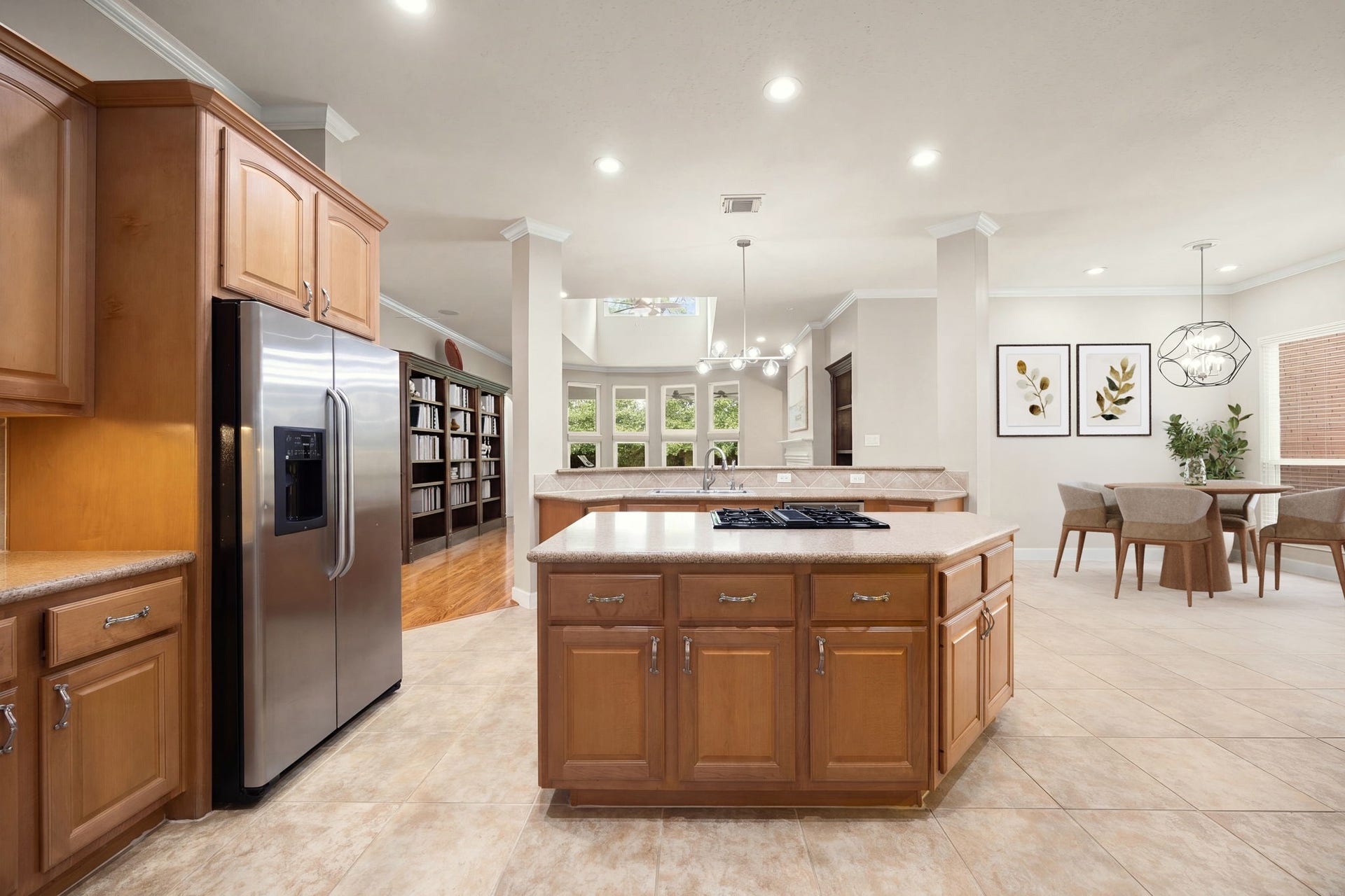 4110 Garden Cove Court, Katy, TX 77494 This expansive kitchen workspace features an oversized center island with a built-in cooktop, premium stainless steel appliances, and a matching refrigerator. The sprawling layout seamlessly connects the kitchen to the casual dining area, formal dining space, and main living room, offering the perfect arrangement for daily meals and grand-scale holiday hosting.