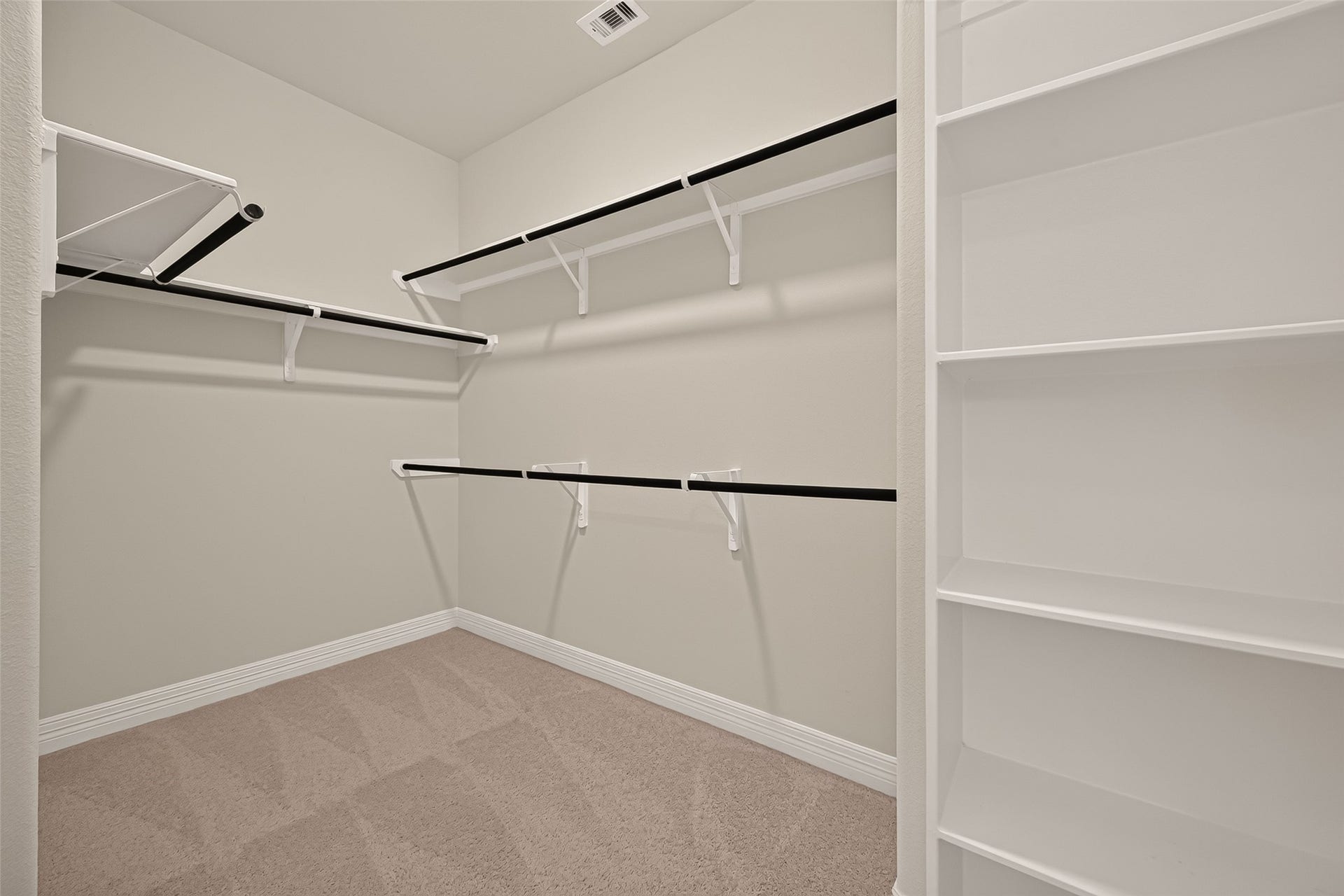 7423 Sunlit Harbor Drive, Cypress, TX 77433 Spacious primary closet featuring custom built-in shelving and organized clothing rods.