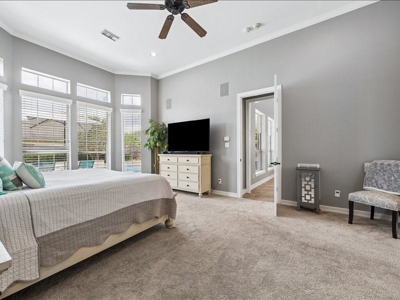 9007 Avebury Stone Circle, Missouri City, TX 77459 Retreat to this generously sized primary bedroom downstairs featuring carpet, crown molding, a ceiling fan, multiple windows overlooking the pool, and a dedicated seating area. Think of it as your private sanctuary at the end of every day.