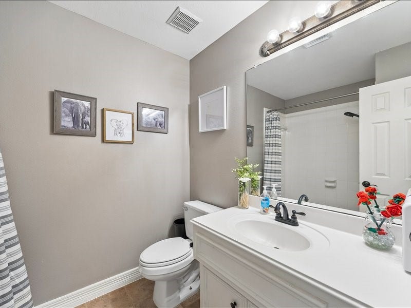 9007 Avebury Stone Circle, Missouri City, TX 77459 A clean and classic full bathroom with tub/shower combination, white single-sink vanity, a large mirror and accent decor. A well-maintained and fully functional bath serving the secondary bedrooms.