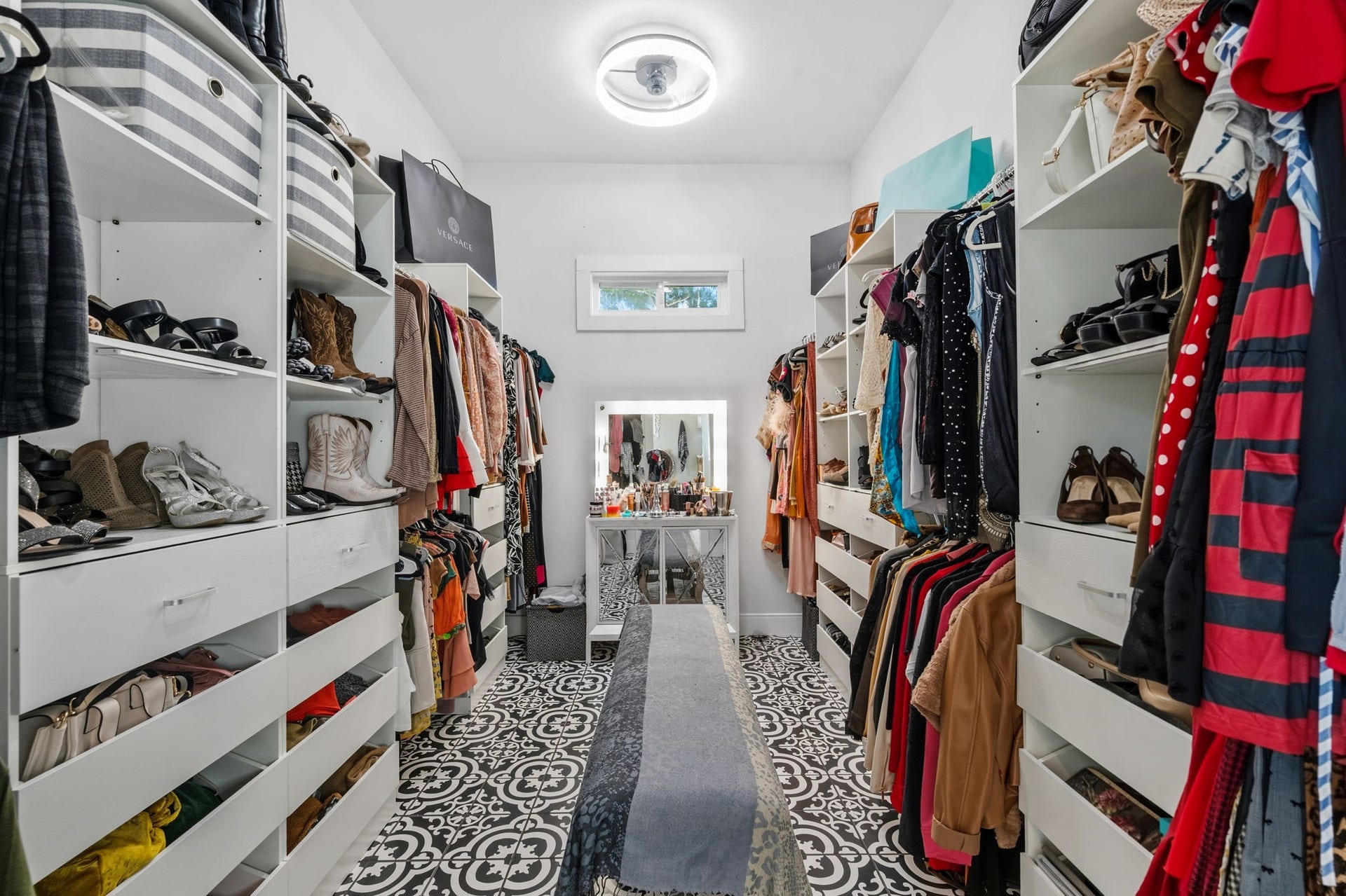 A walk in closet with built in storage.