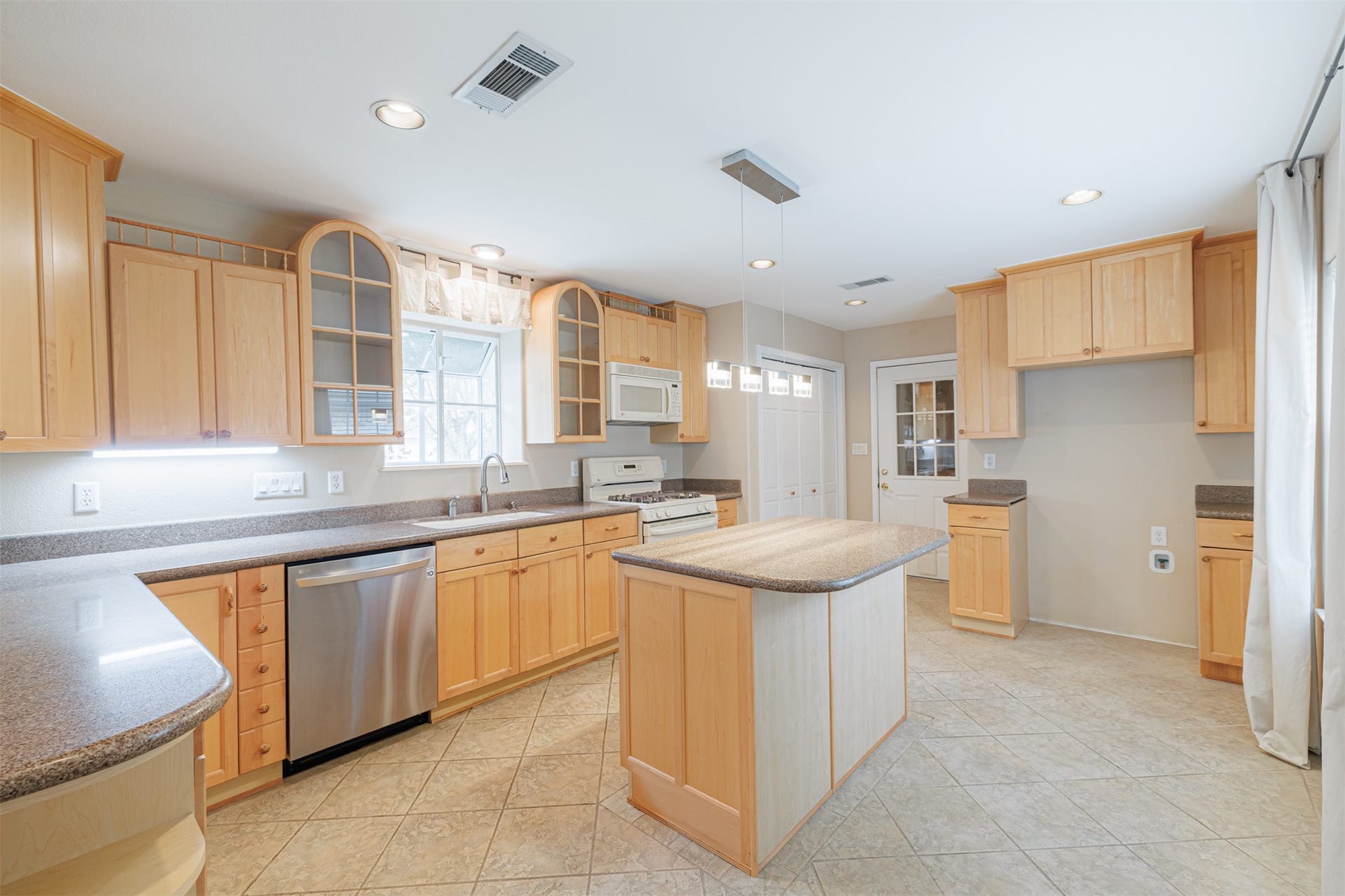 519 E Hillary Circle, Sugar Land, TX 77498 The kitchen shines with custom glass cabinetry, Avanza countertops, stainless steel appliances, breakfast bar, and center island.
